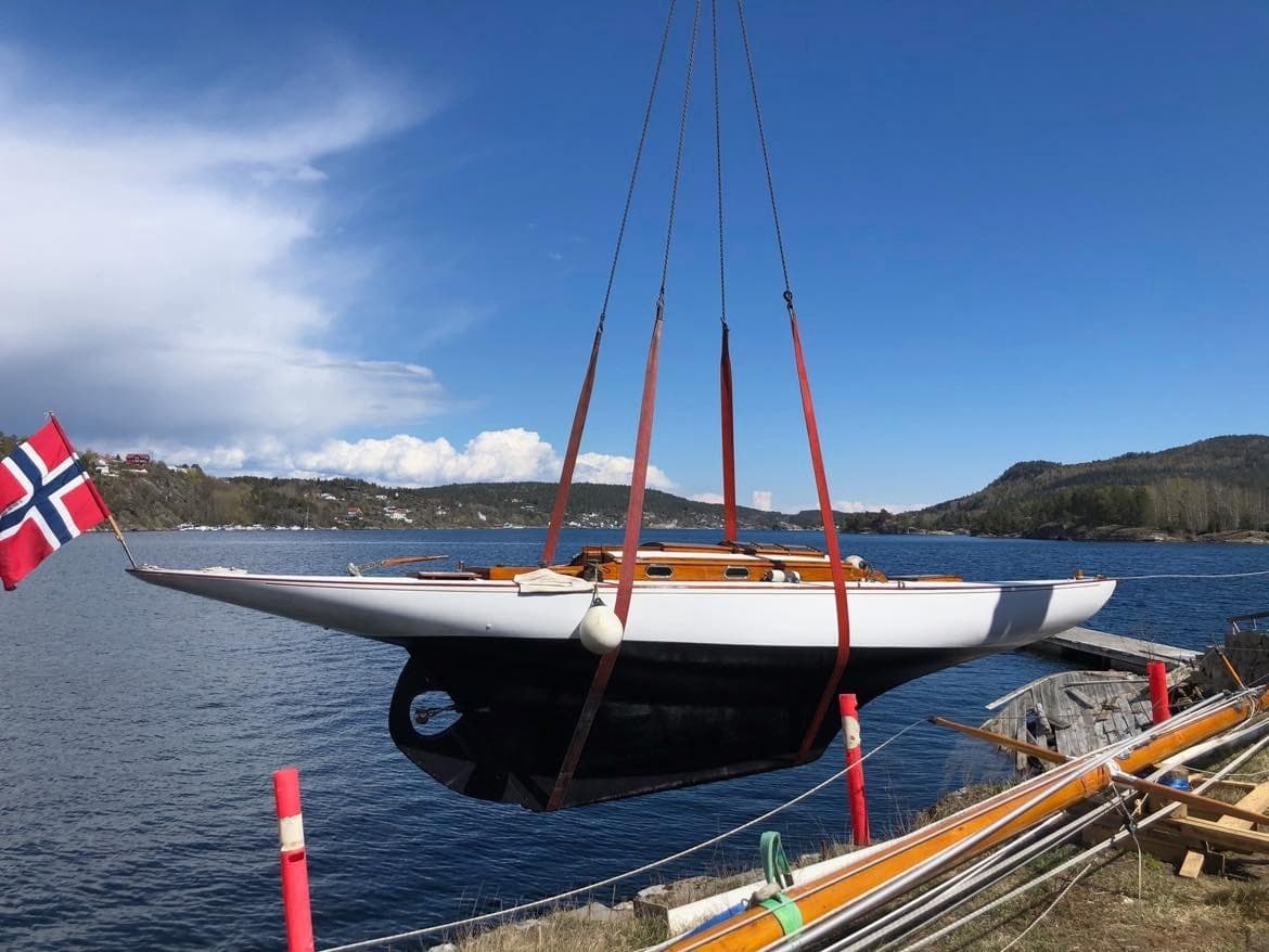 Anker & Jensen 8mR yacht from 1914 being lifted over water.