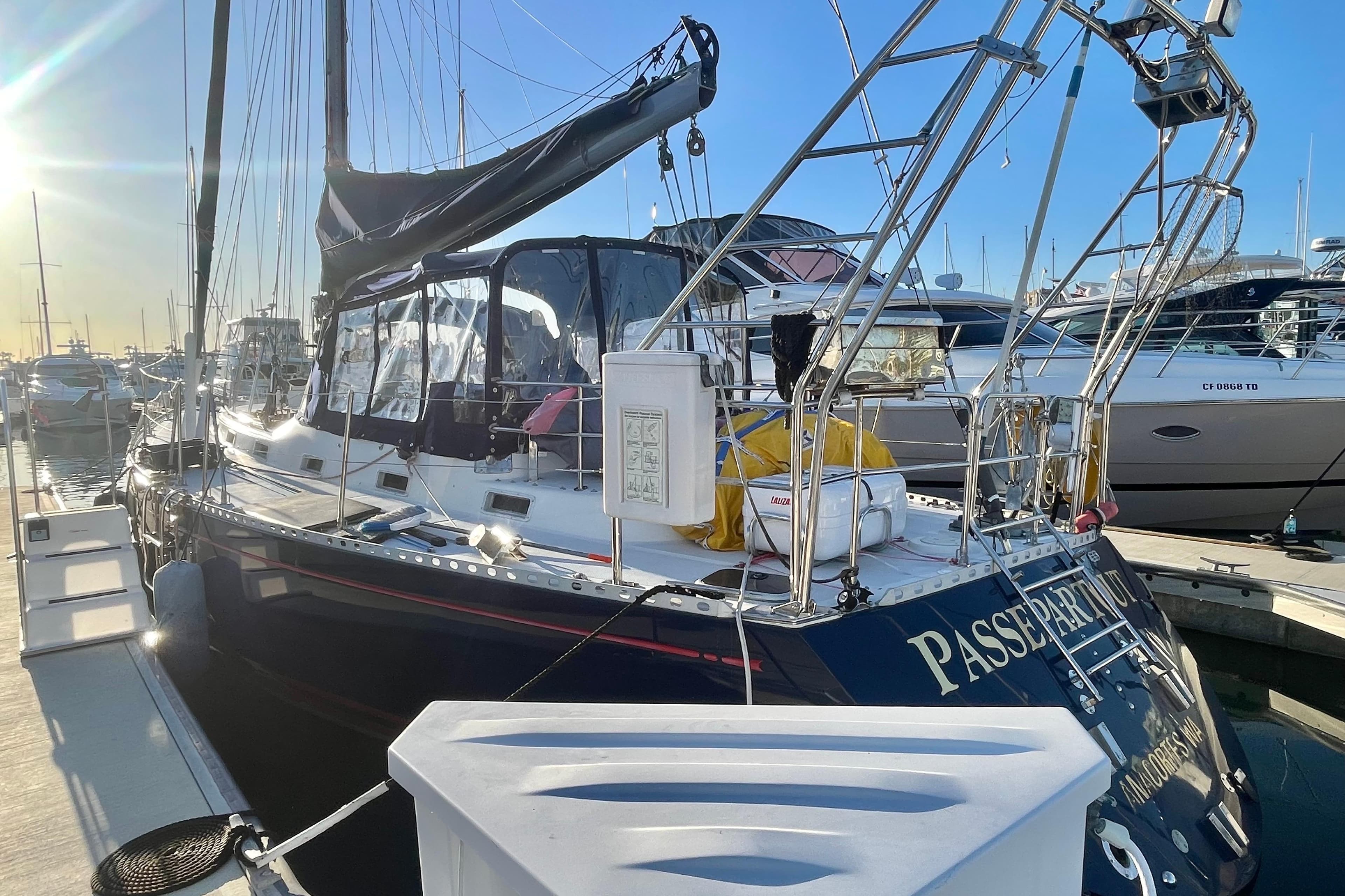 1982 Stevens cutter sailboat docked in marina, sunlit with clear blue sky.