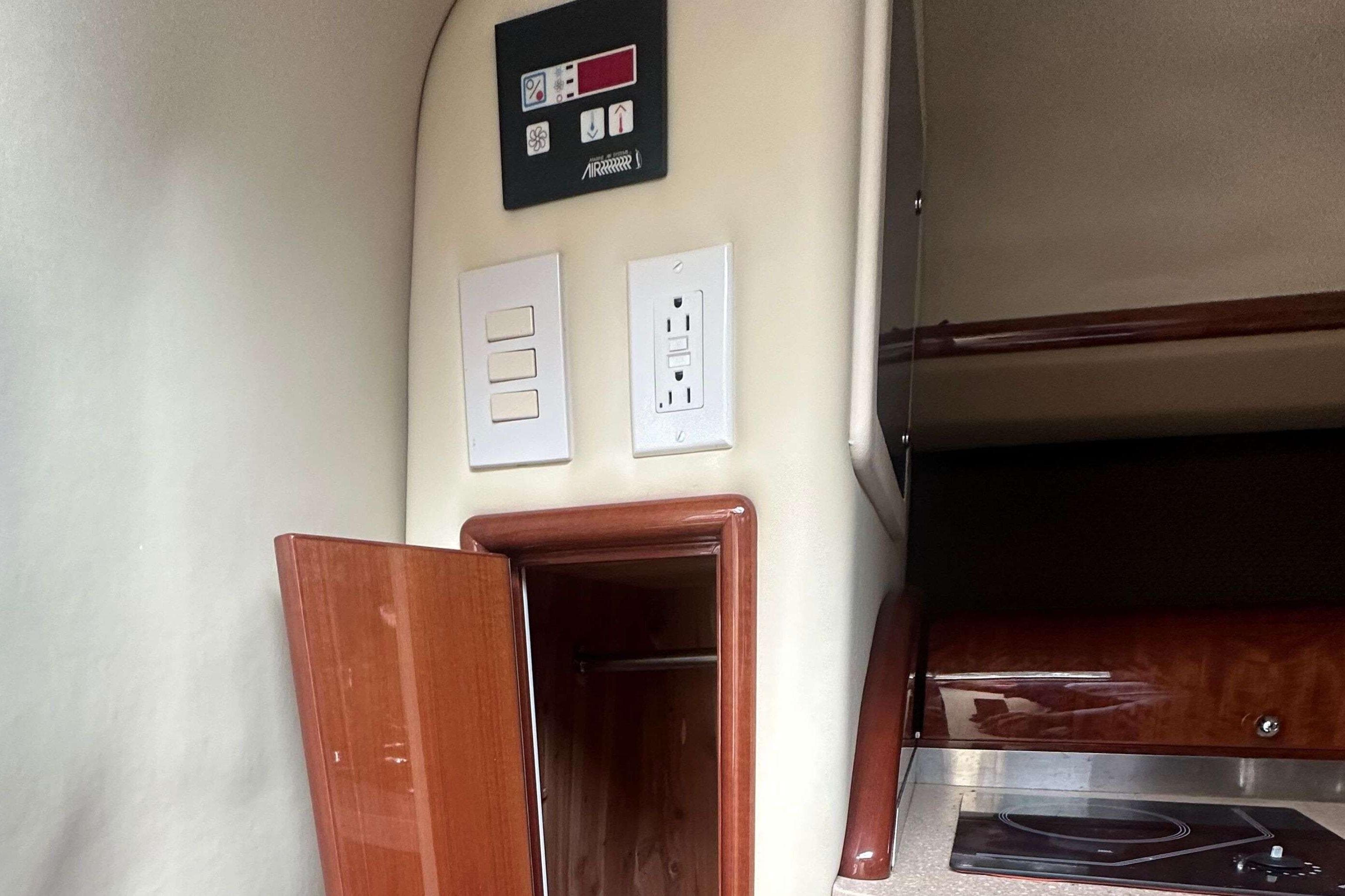 Interior of a 2008 Cobalt 323 boat featuring control panel and wooden cabinetry.