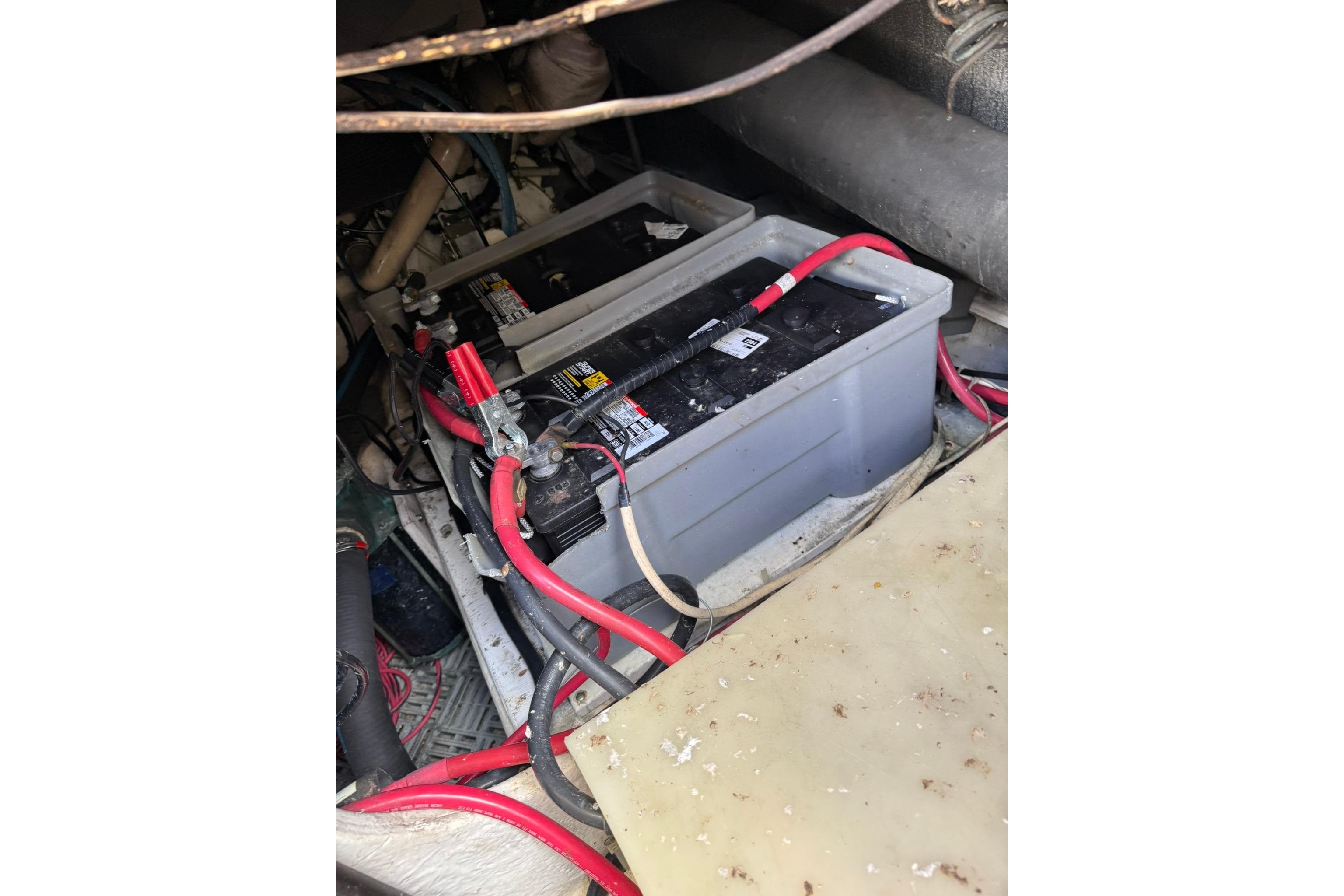 Battery compartment of a 1999 Maxum 4600 SCB with red and black cables.