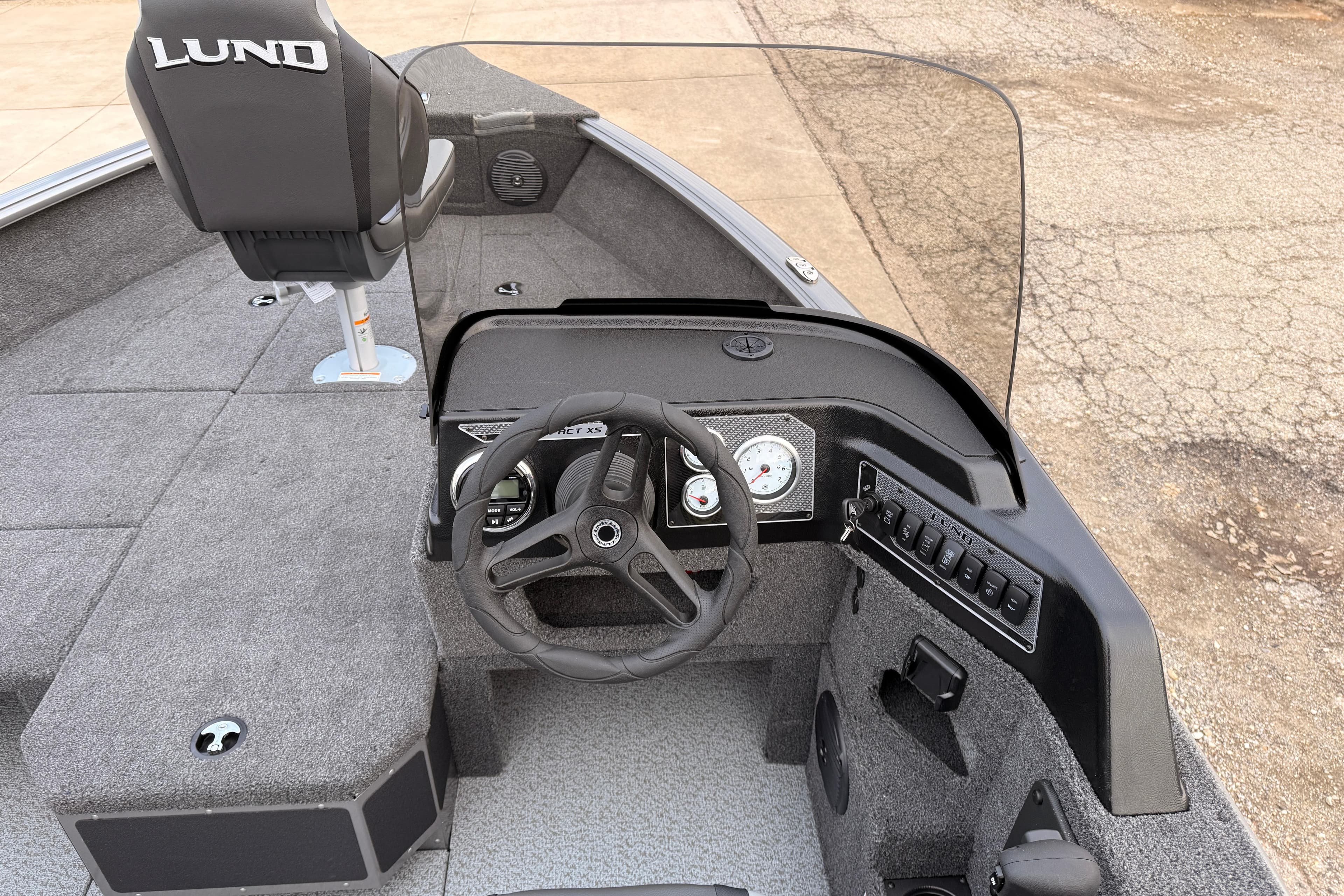 2026 Lund 1775 Impact XS SS boat interior with steering wheel and dashboard controls.