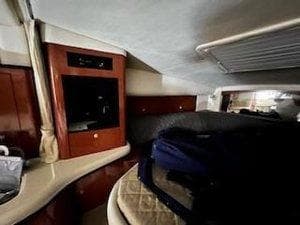 Interior cabin of 2005 Sea Ray 320 Sundancer with wood cabinetry and seating area.