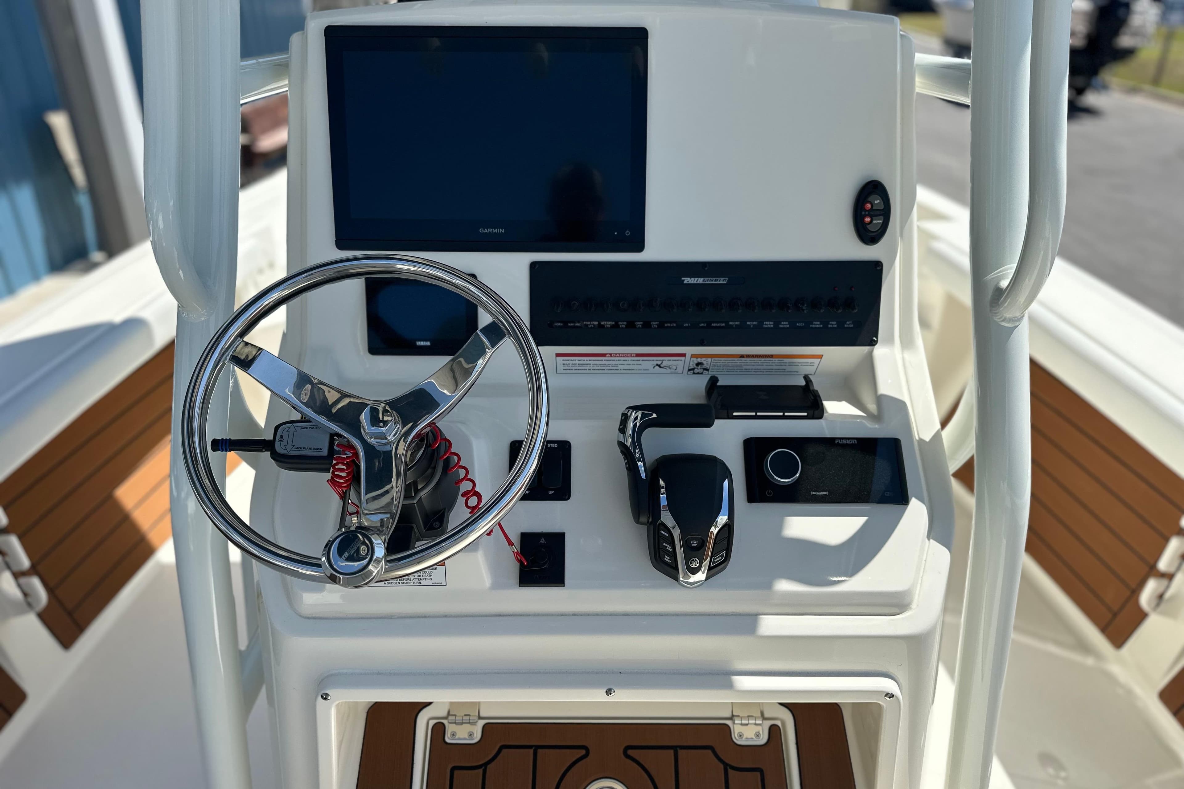 2026 Pathfinder 2400 TRS boat dashboard with steering wheel and navigation controls.
