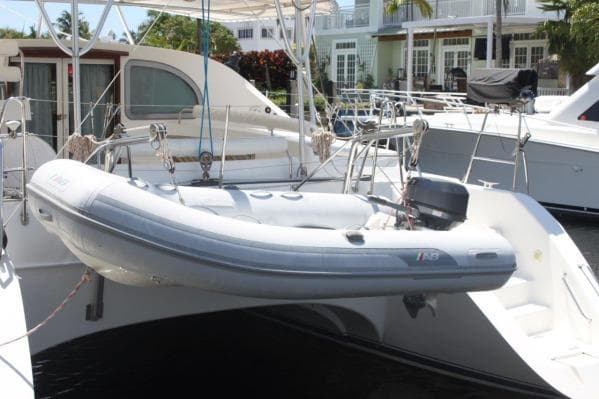 2006 Alliaura Marine Privilege 435 EZC catamaran with dinghy, docked at marina.