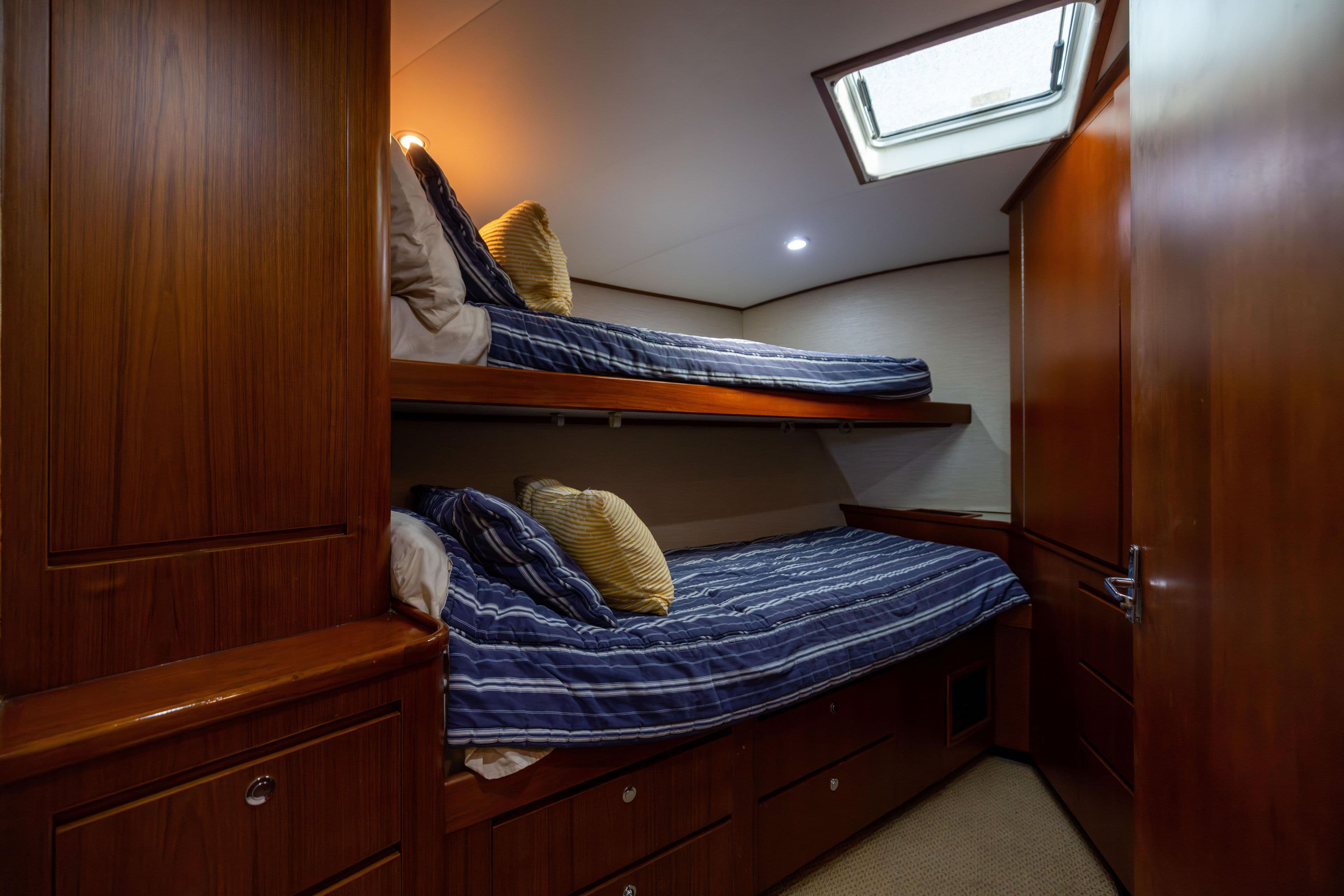 Bunk beds in a 1996 Jim Smith 60 Sportfish yacht cabin with wood paneling.