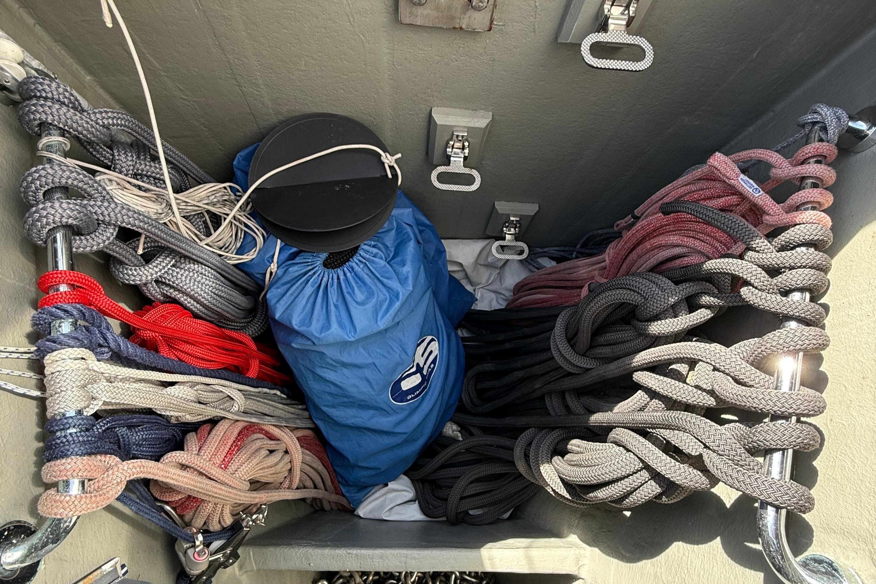 Storage compartment with neatly coiled ropes and a blue bag on a Contest 67CS yacht.