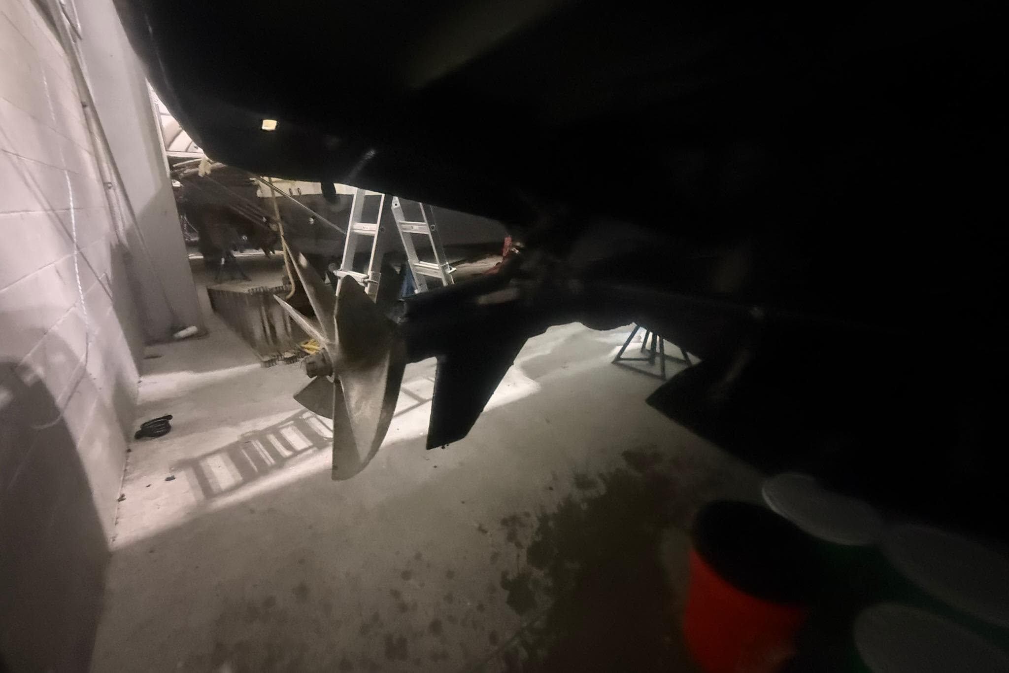 Boat propeller and rudder in a dimly lit garage, Diaship 53, 1999 model.
