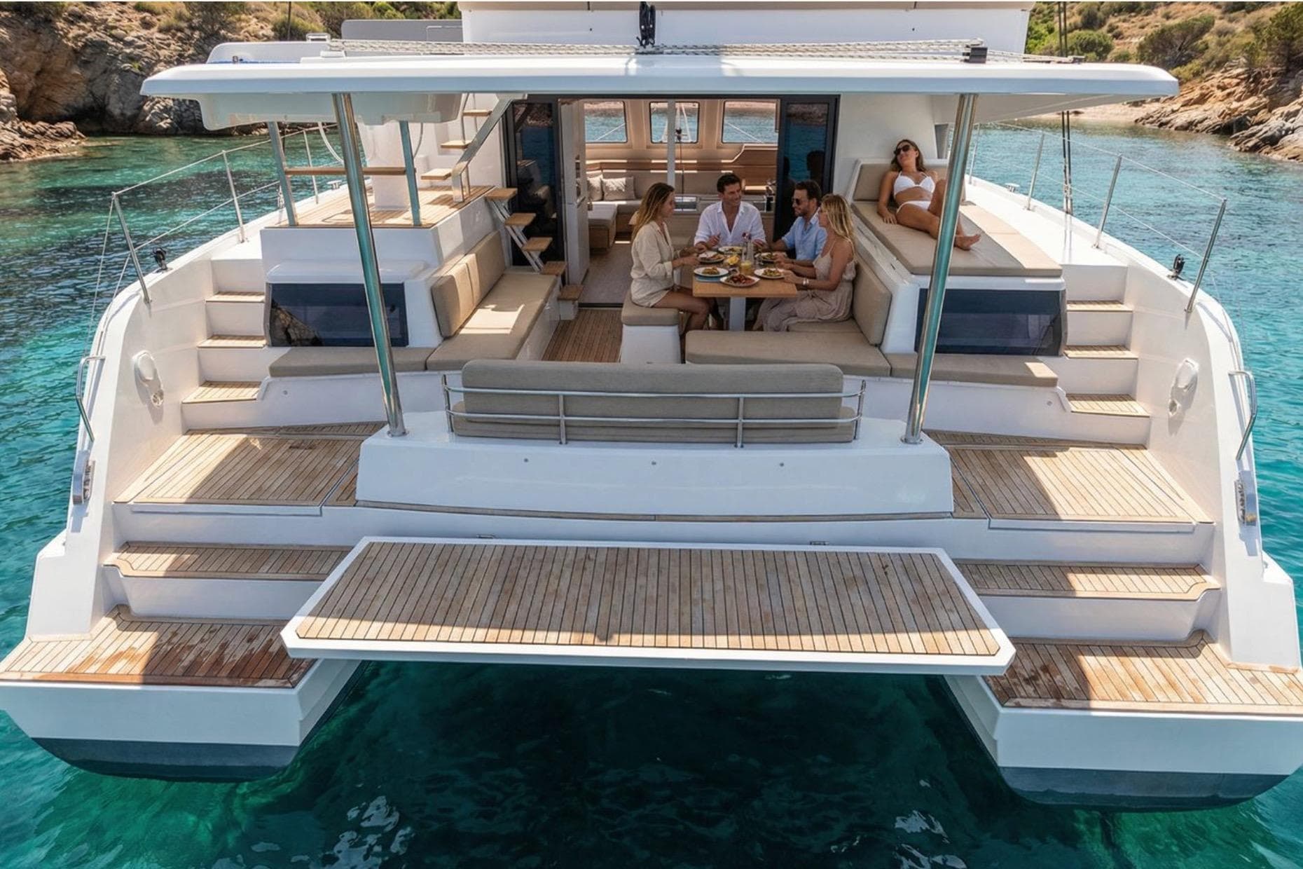 Luxury Aventura 43 yacht, 2026 model, with people dining on deck in clear blue waters.