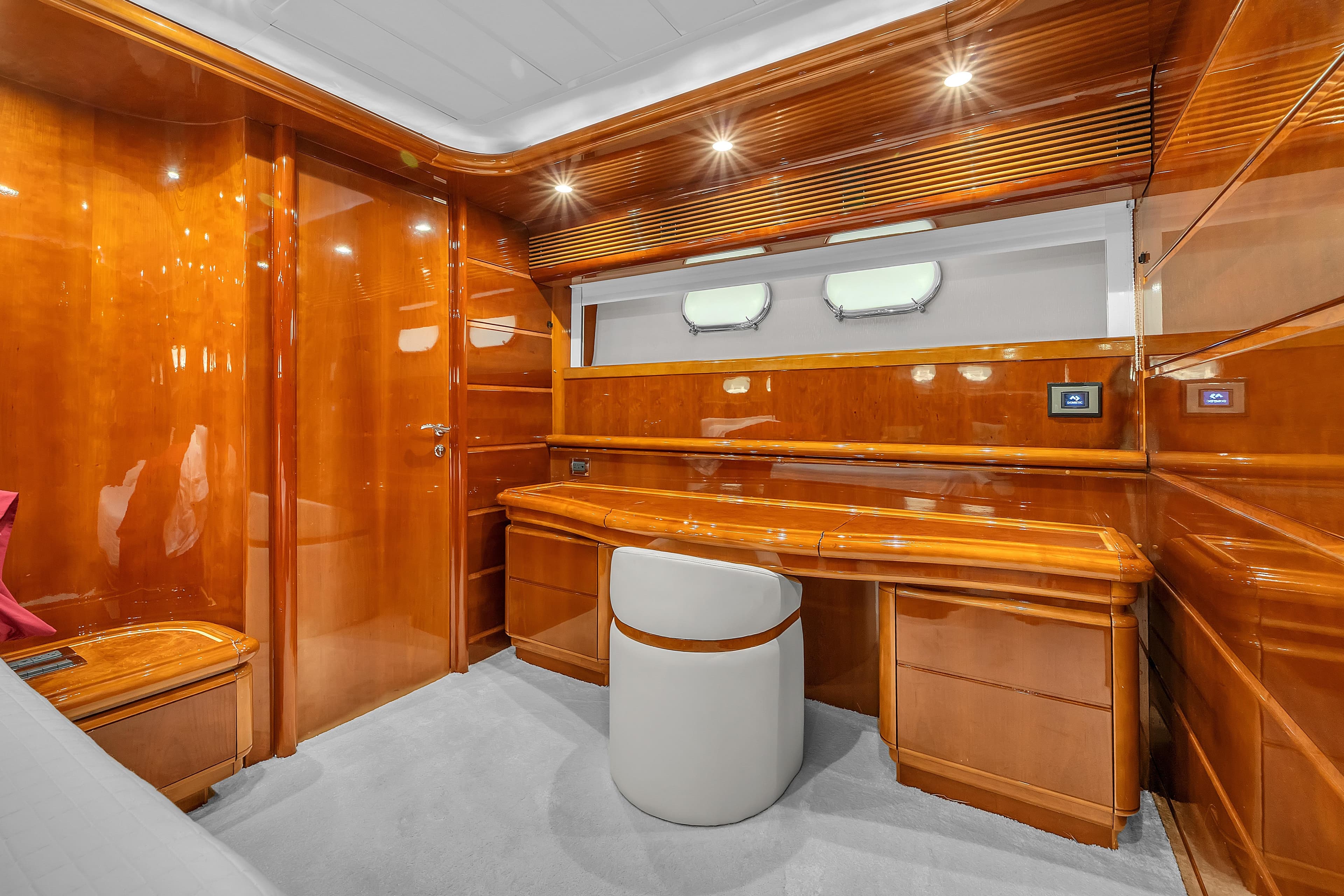 Luxurious wooden interior of 2002 Ferretti Yachts Custom Line 94 cabin with desk and seating.