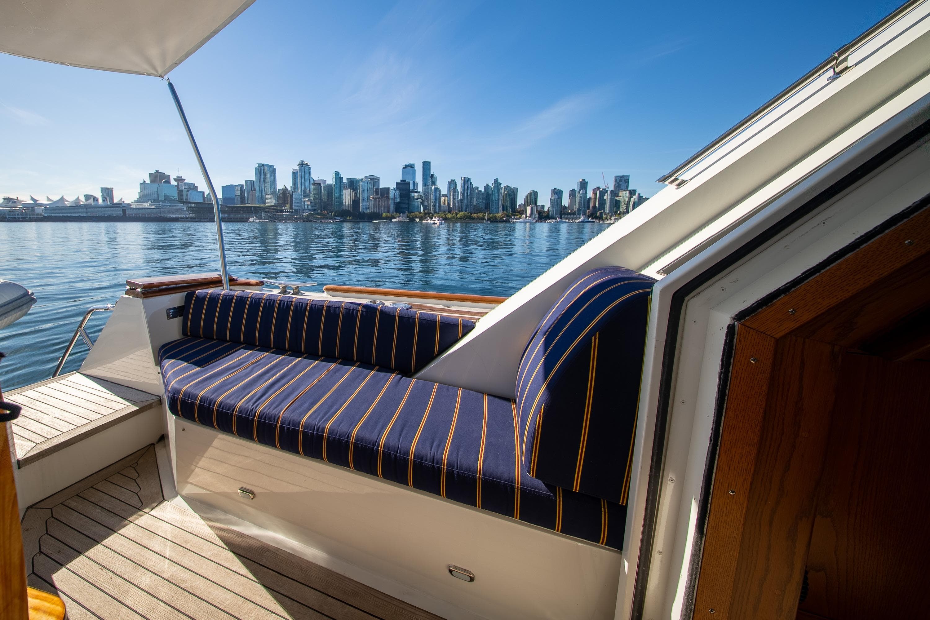 1988 Philbrooks Pilot House Motor Yacht with city skyline view, featuring striped seating.