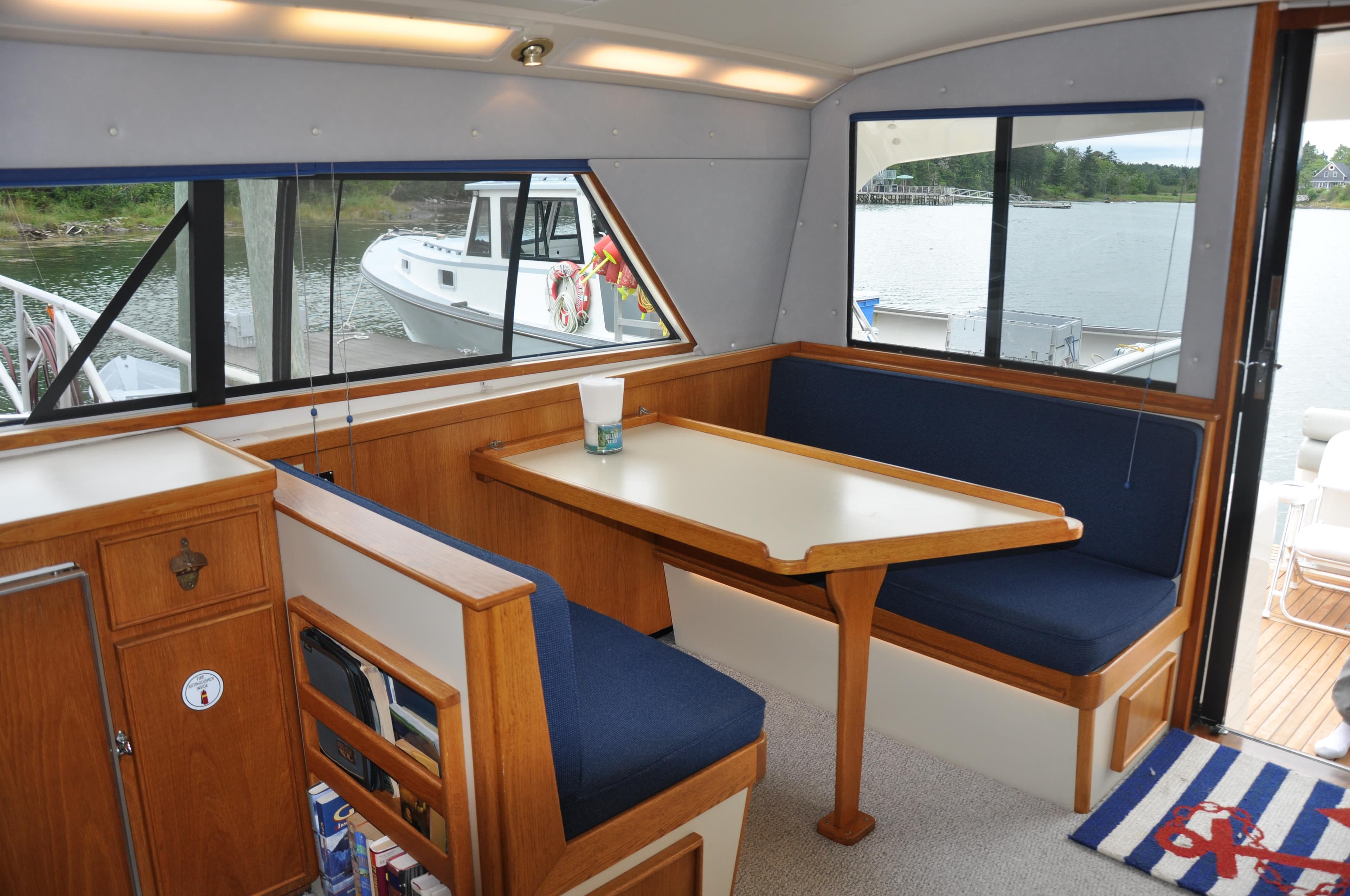 Interior of 1987 Bertram 37 Convertible yacht with dining area and waterfront view.