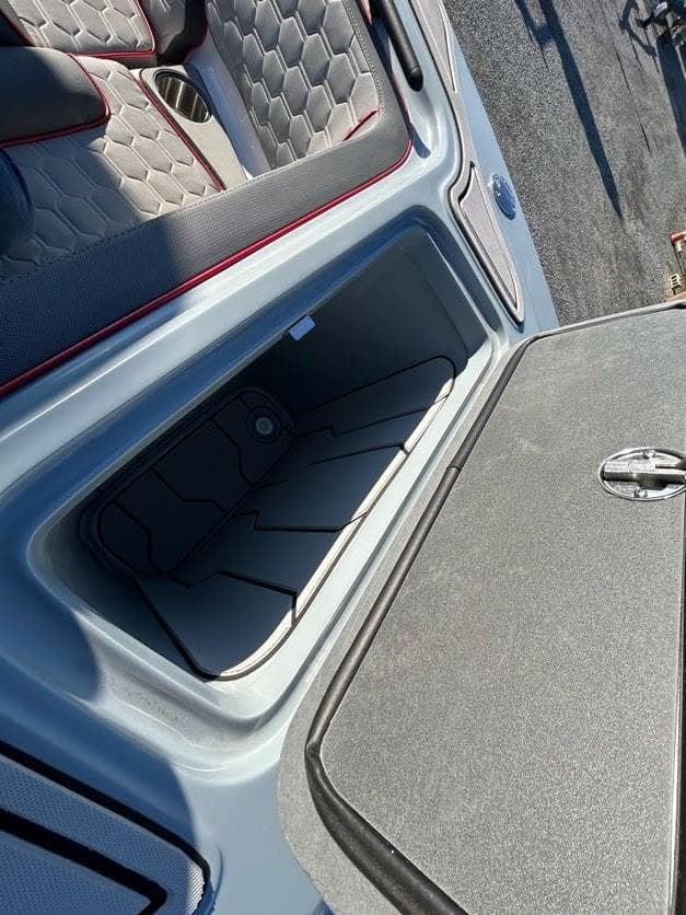 2024 Glasstream 32 GSX boat storage compartment with open lid and cushioned seating.