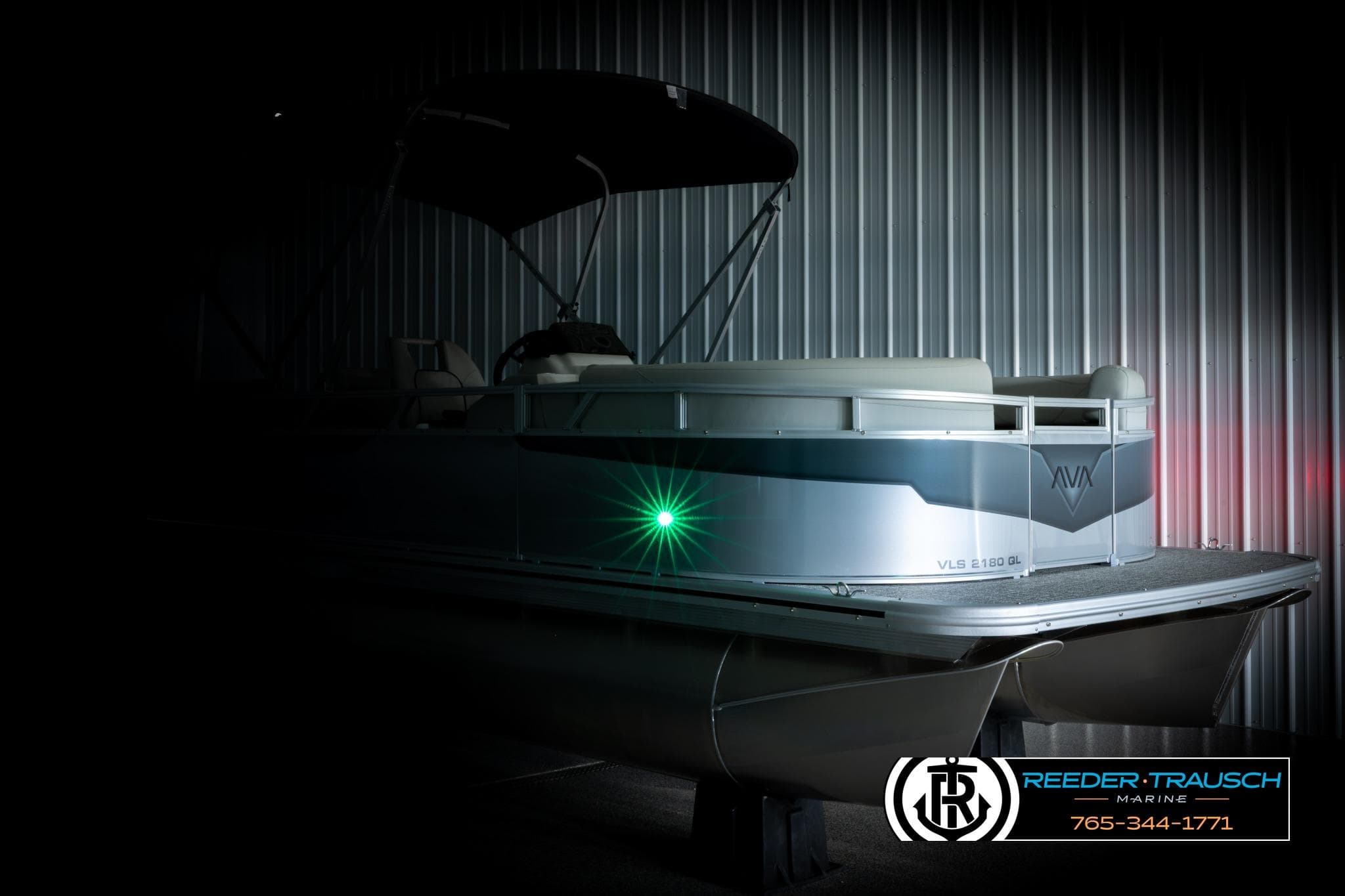 2026 Avalon VLS QL pontoon boat in dimly lit showroom, showcasing sleek design.