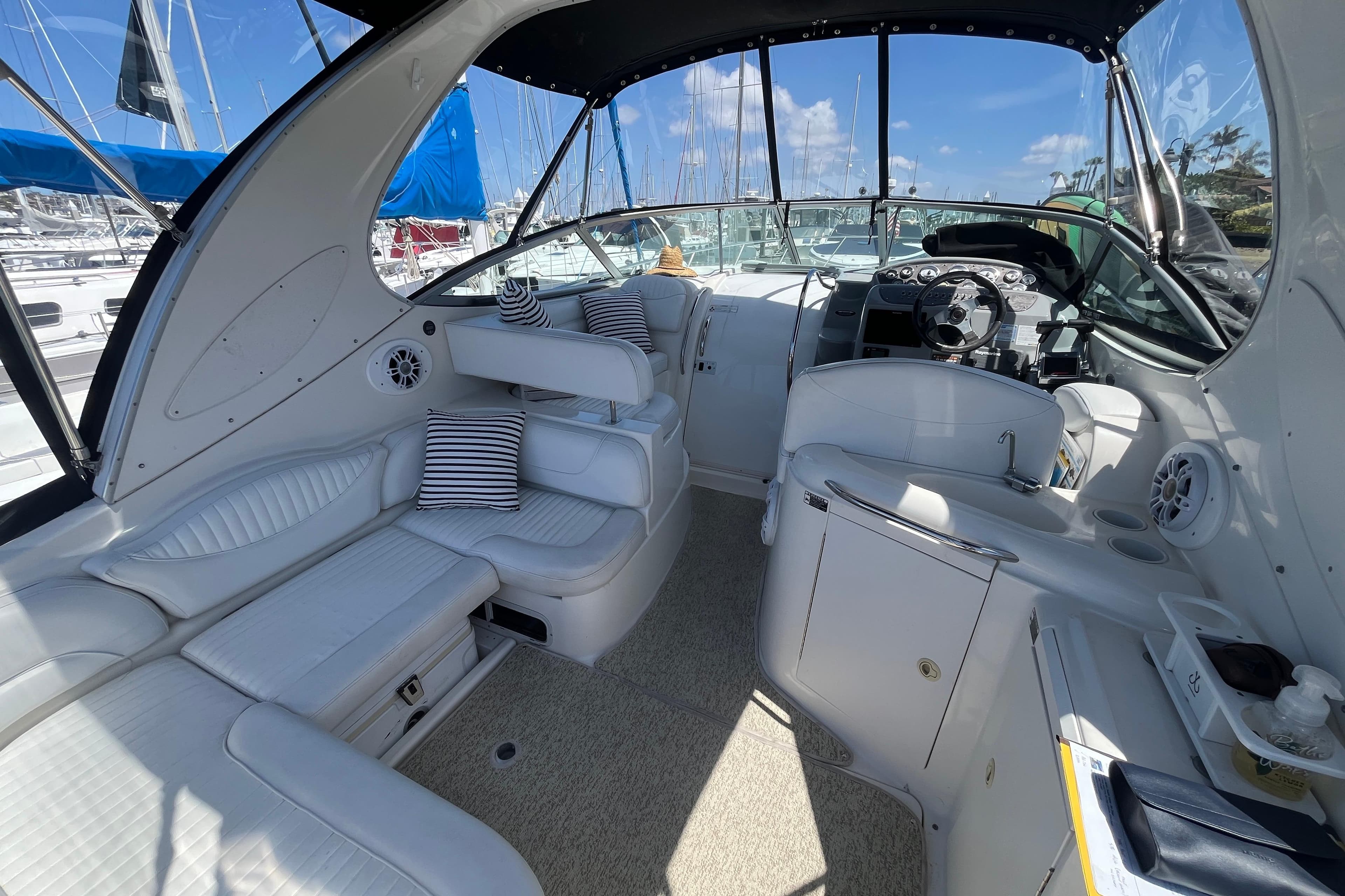 2007 Maxum 3100 SE boat interior with white seating and striped cushions.