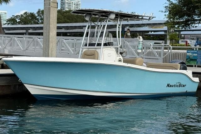 2019 NauticStar 20 XS boat docked in marina, featuring sleek blue hull and T-top.