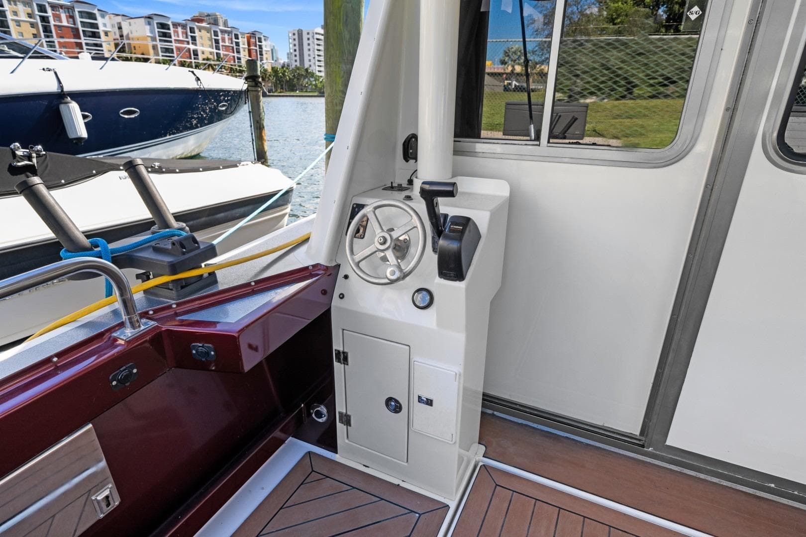 2009 EagleCraft 47' Pilothouse helm station with modern controls, docked near colorful buildings.