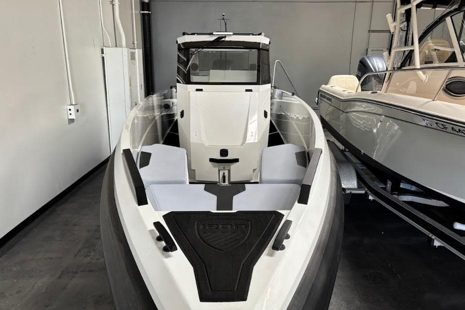 2026 Iron 907 Coupe boat in showroom, sleek design, white and black color scheme.