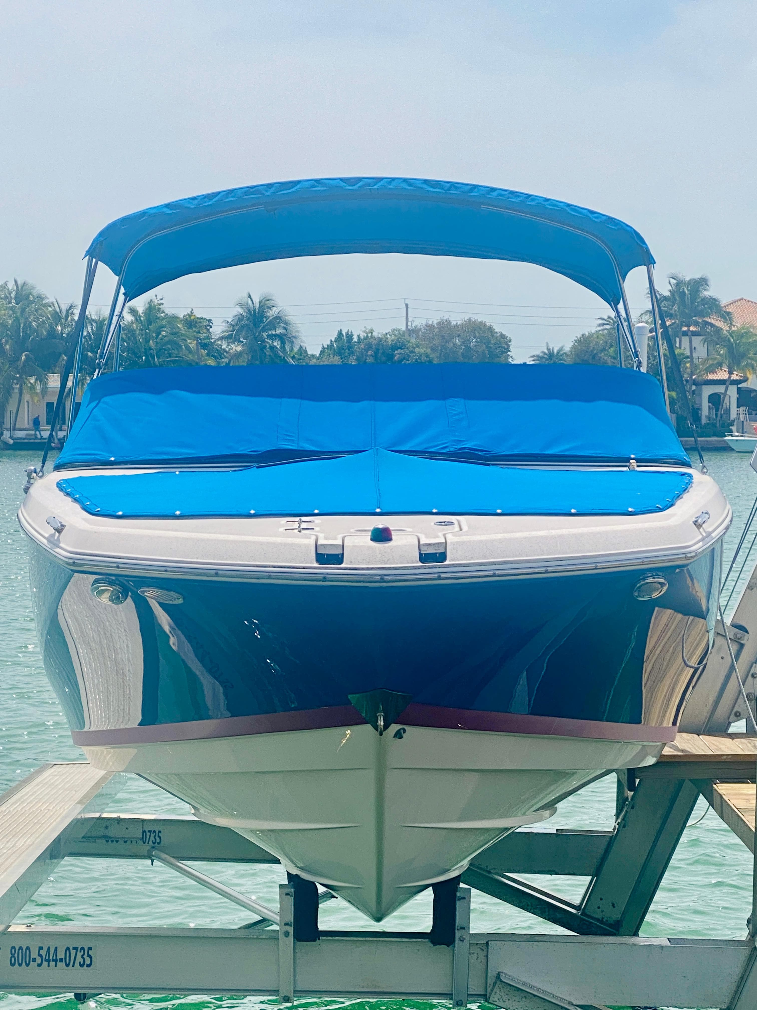 2016 Regal 22 FasDeck boat with blue cover docked on a lift.