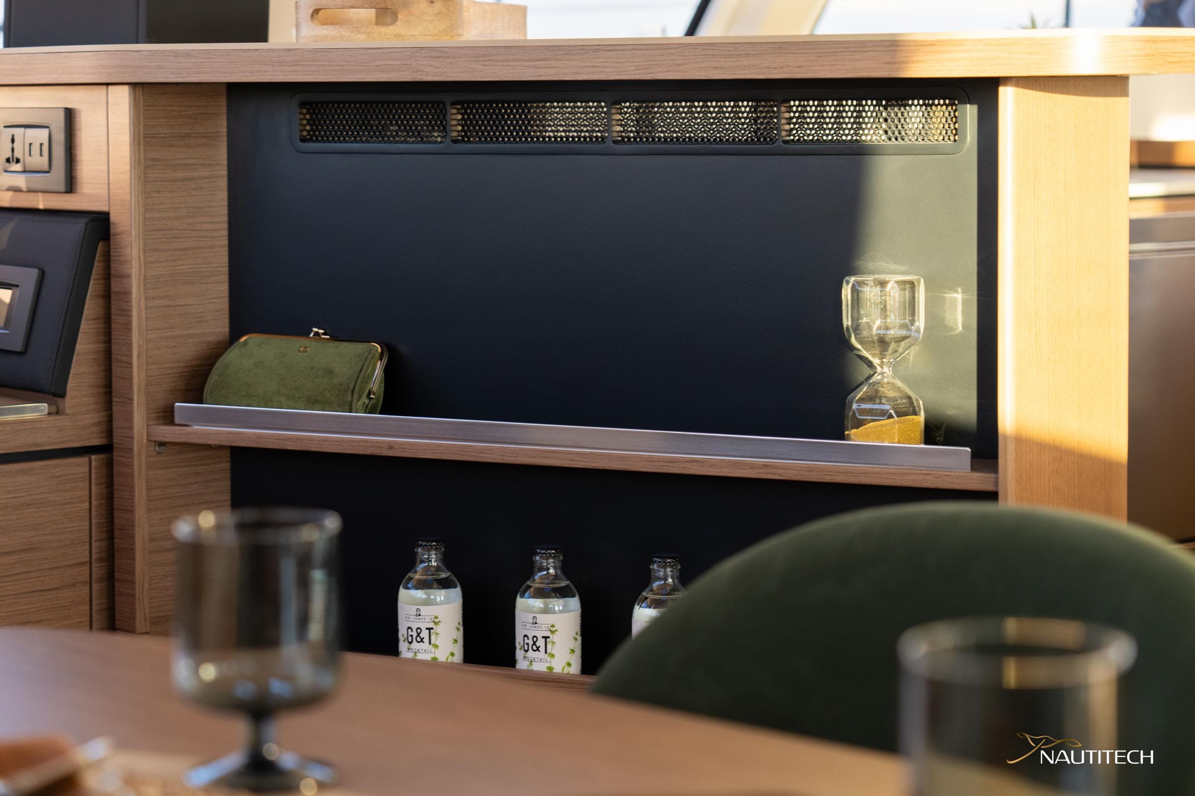 Interior of 2025 Nautitech 48 Open yacht with shelf, bottles, and hourglass.