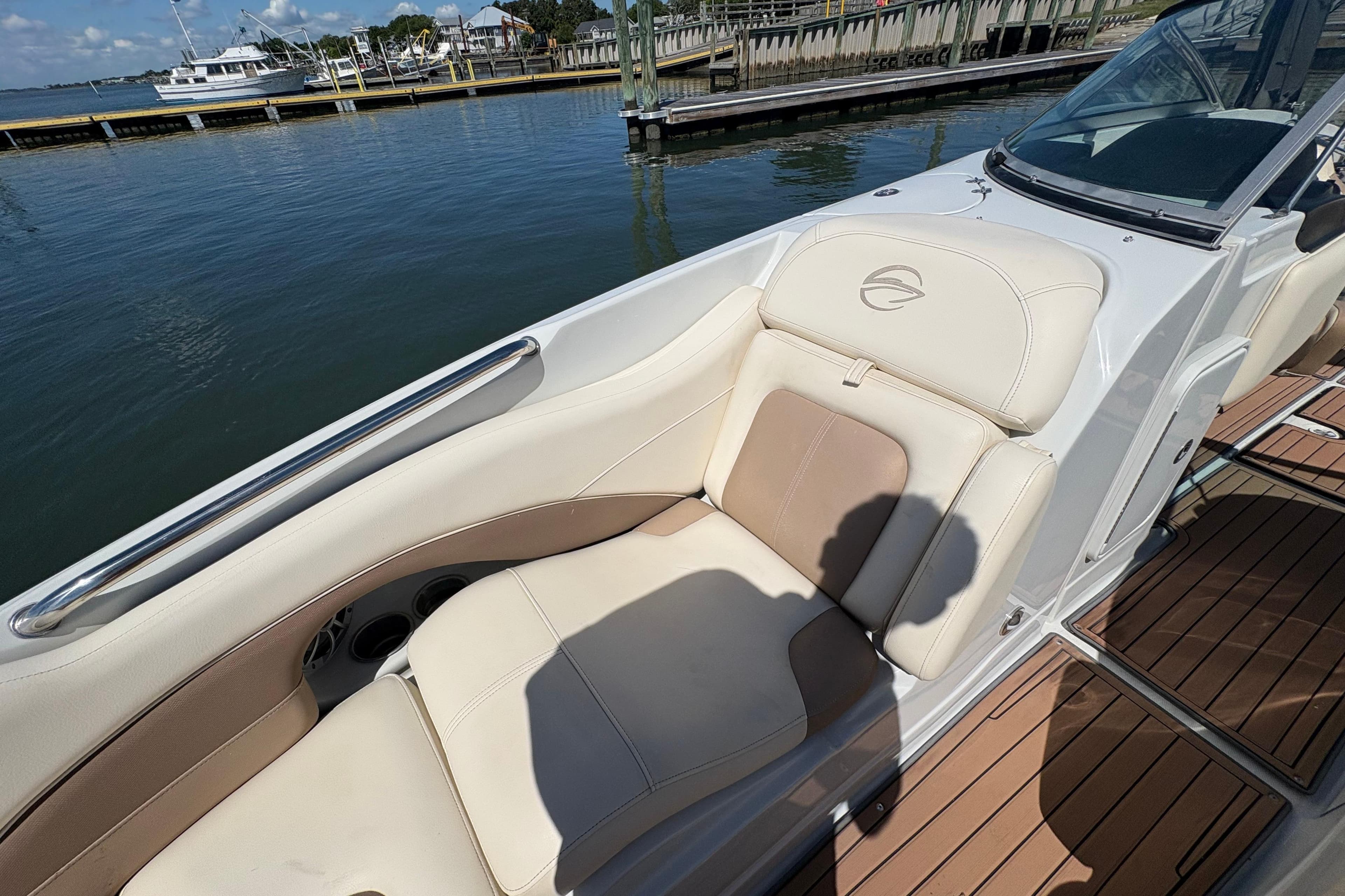 2017 Crownline 275 SS boat with beige seating, docked by the water.