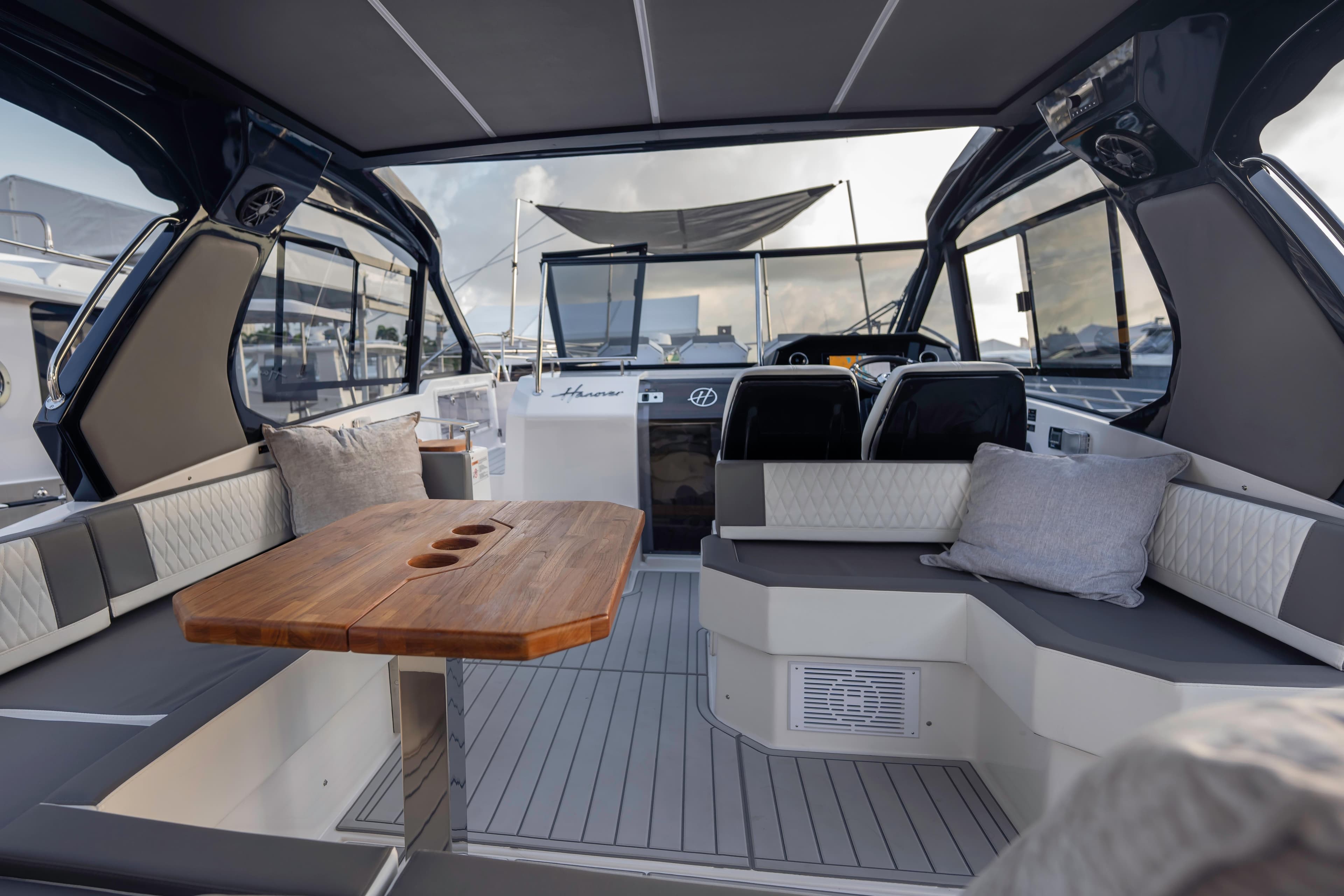 Luxurious interior of 2025 Hanover 387 yacht with elegant seating and wooden table.