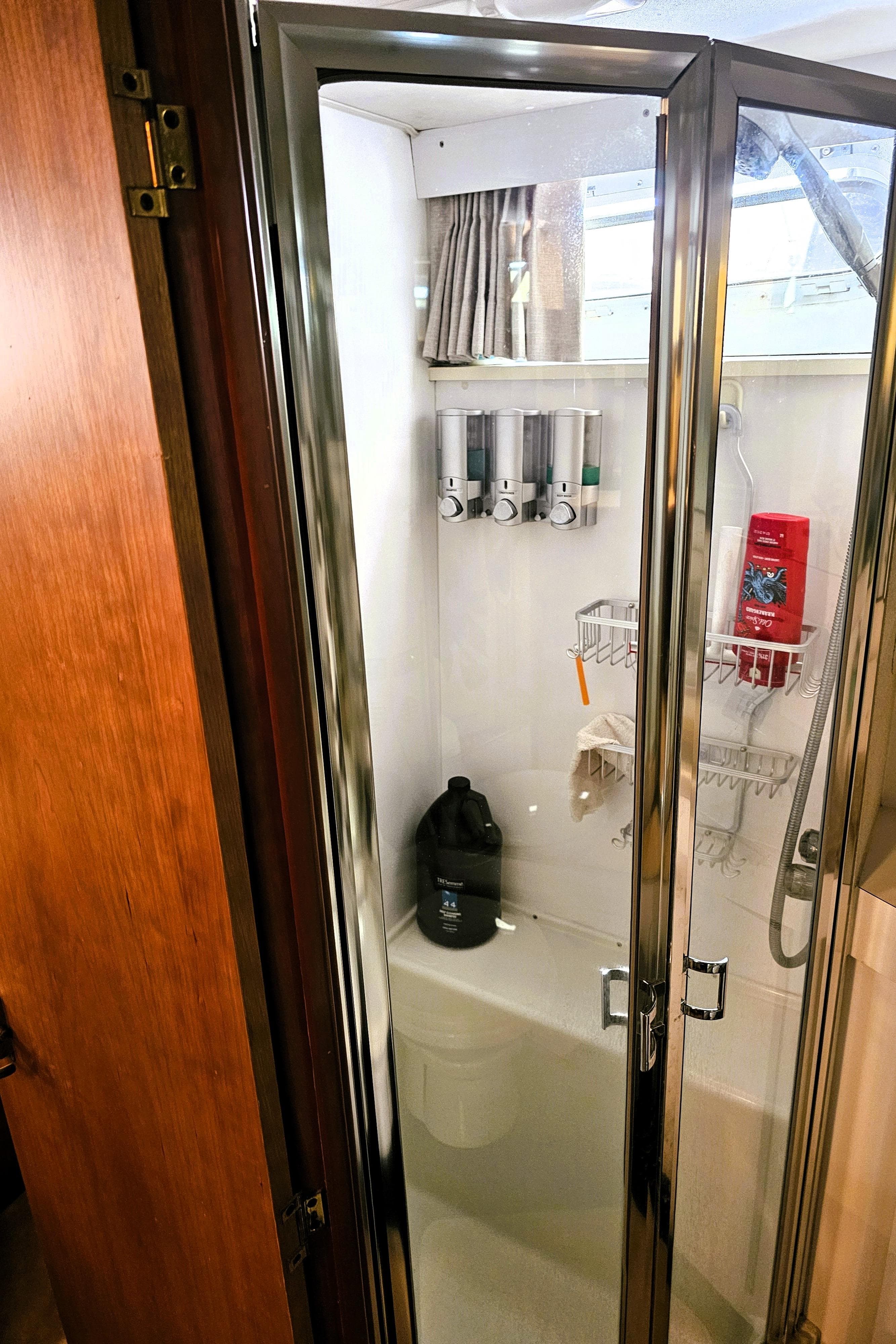 Shower area in a 1995 Silverton 46 yacht with glass door and toiletries.