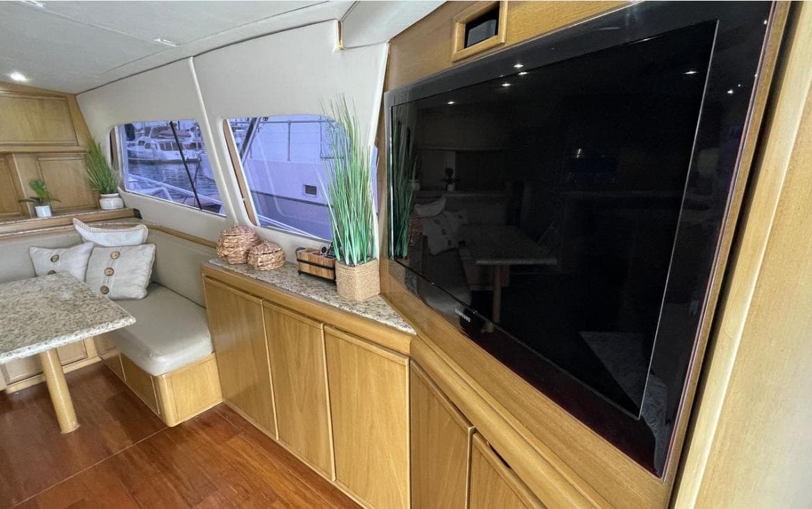 Interior of a 1995 Bertram Convertible yacht with modern decor and large TV.