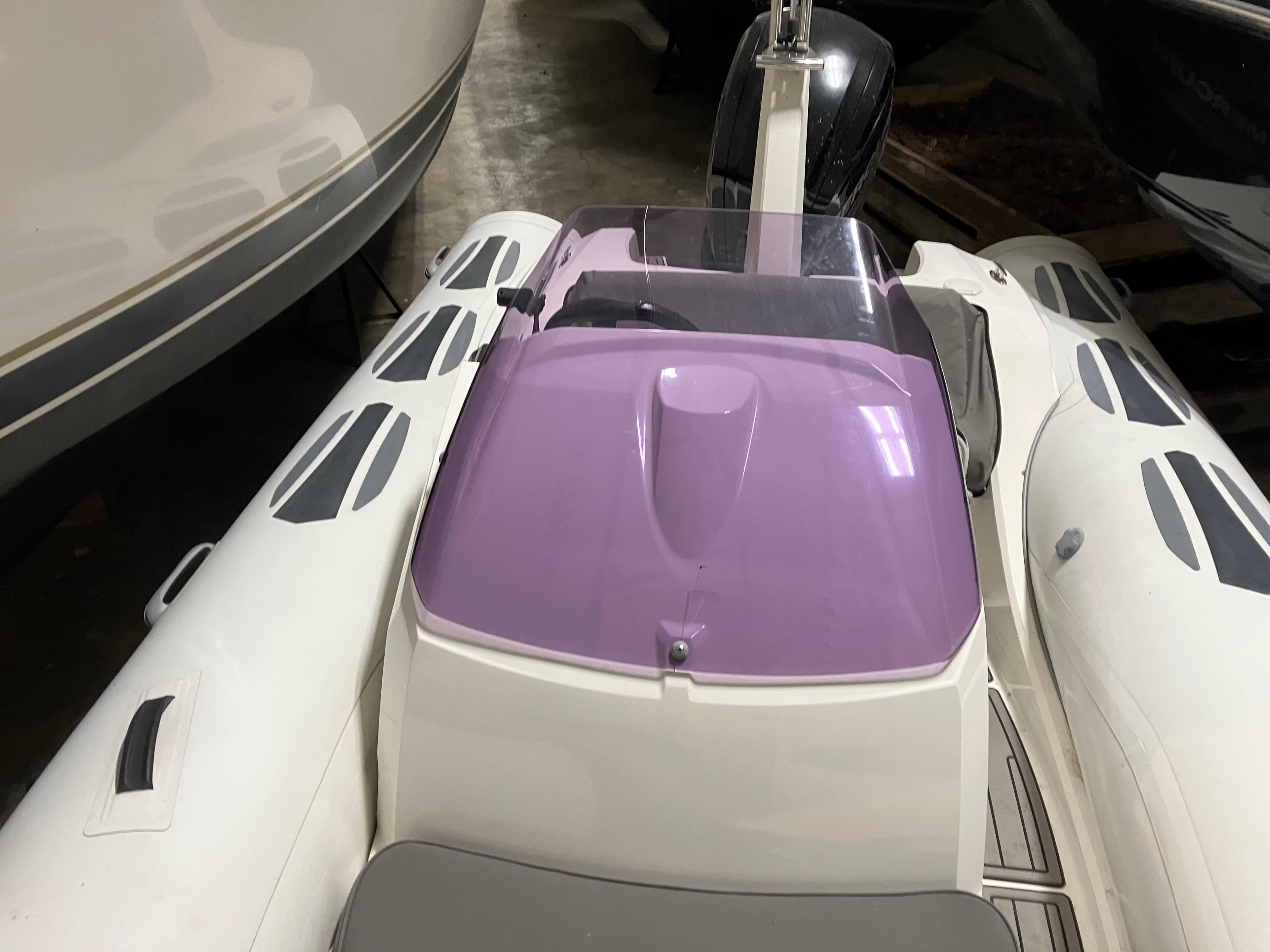2015 Brig Eagle 480 boat with purple windshield, docked indoors.