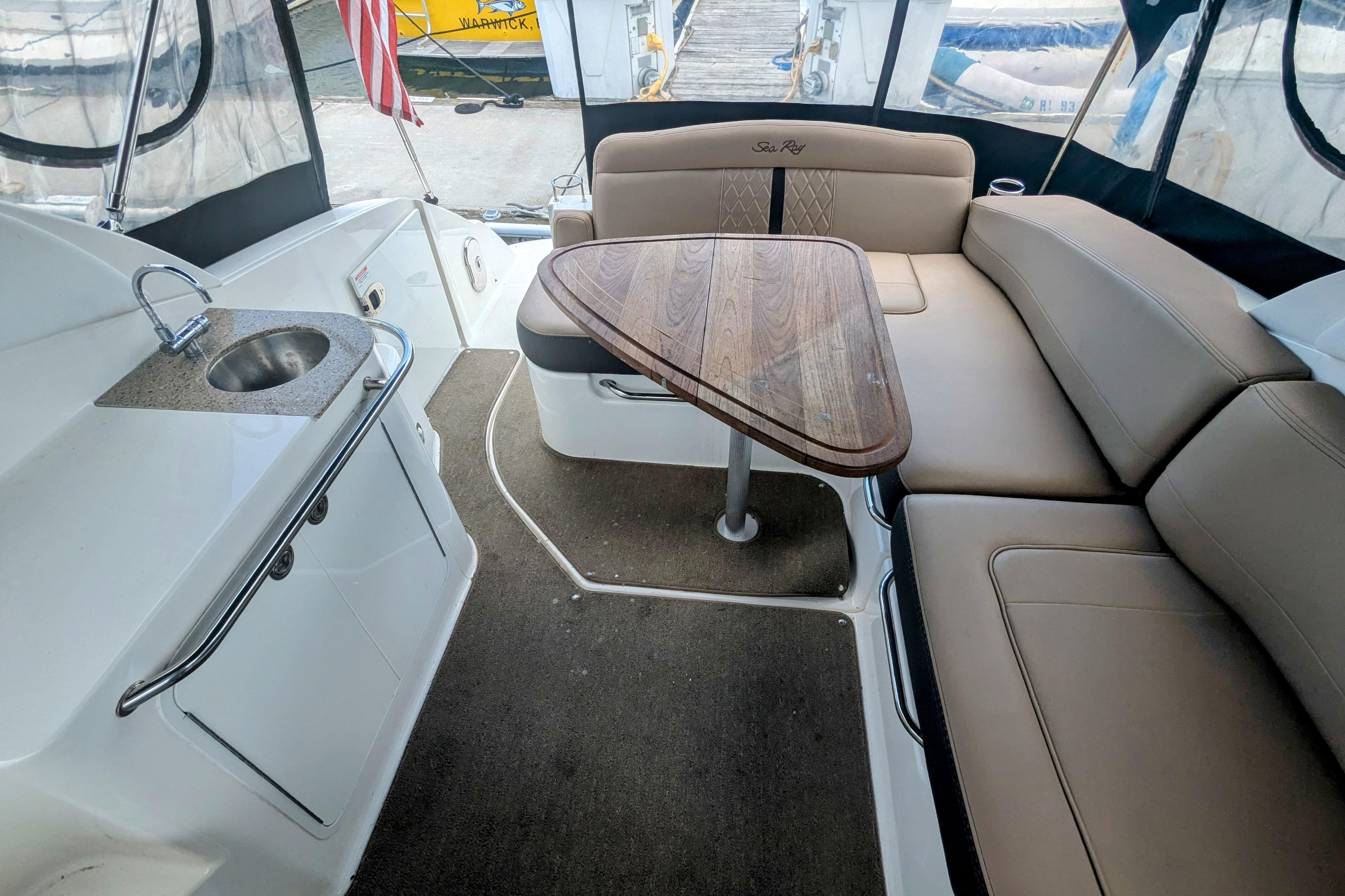 2017 Sea Ray Sundancer 280 interior with seating, table, and sink.