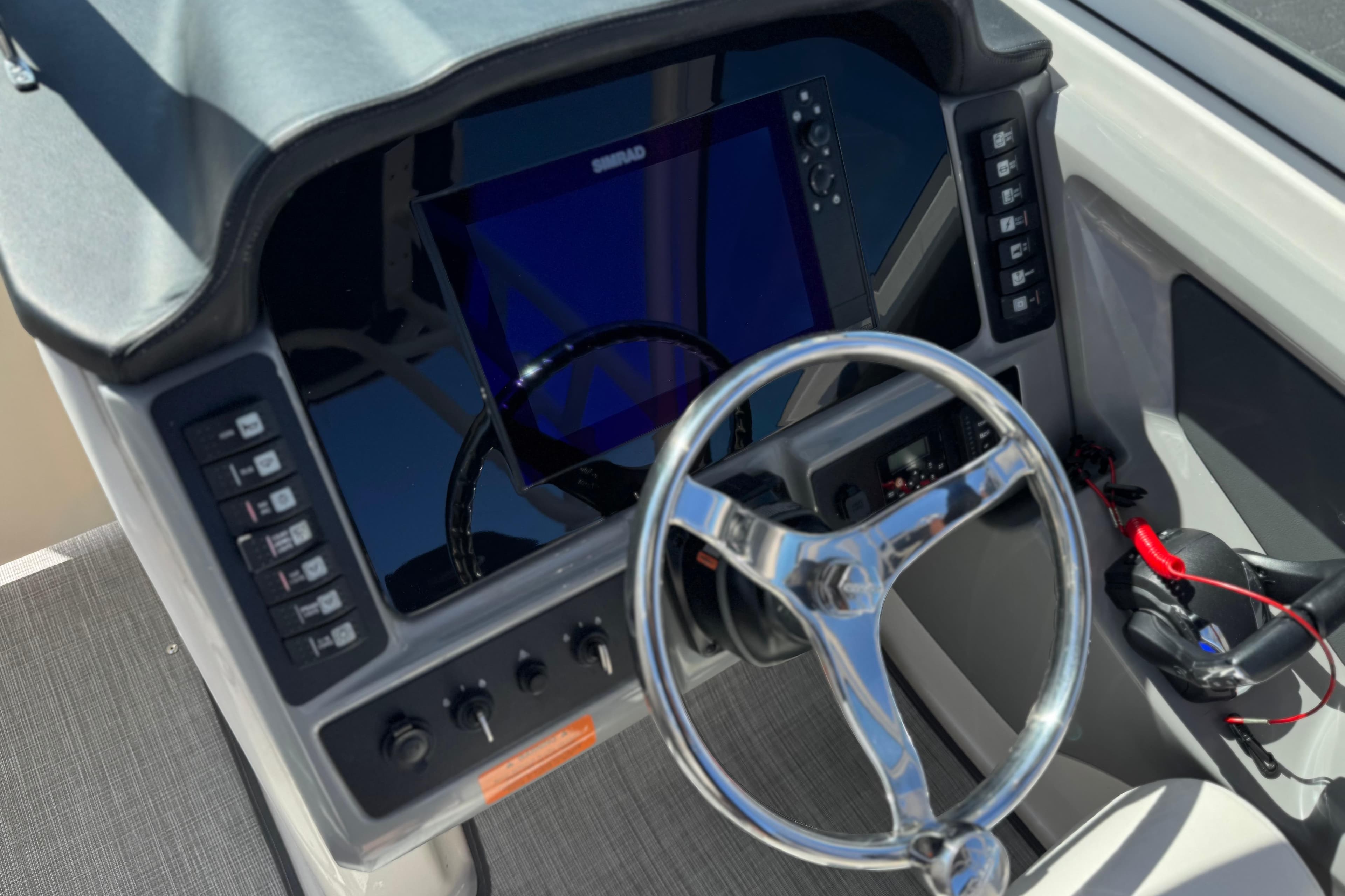 2022 Robalo R247 Dual Console boat dashboard with steering wheel and control panel.