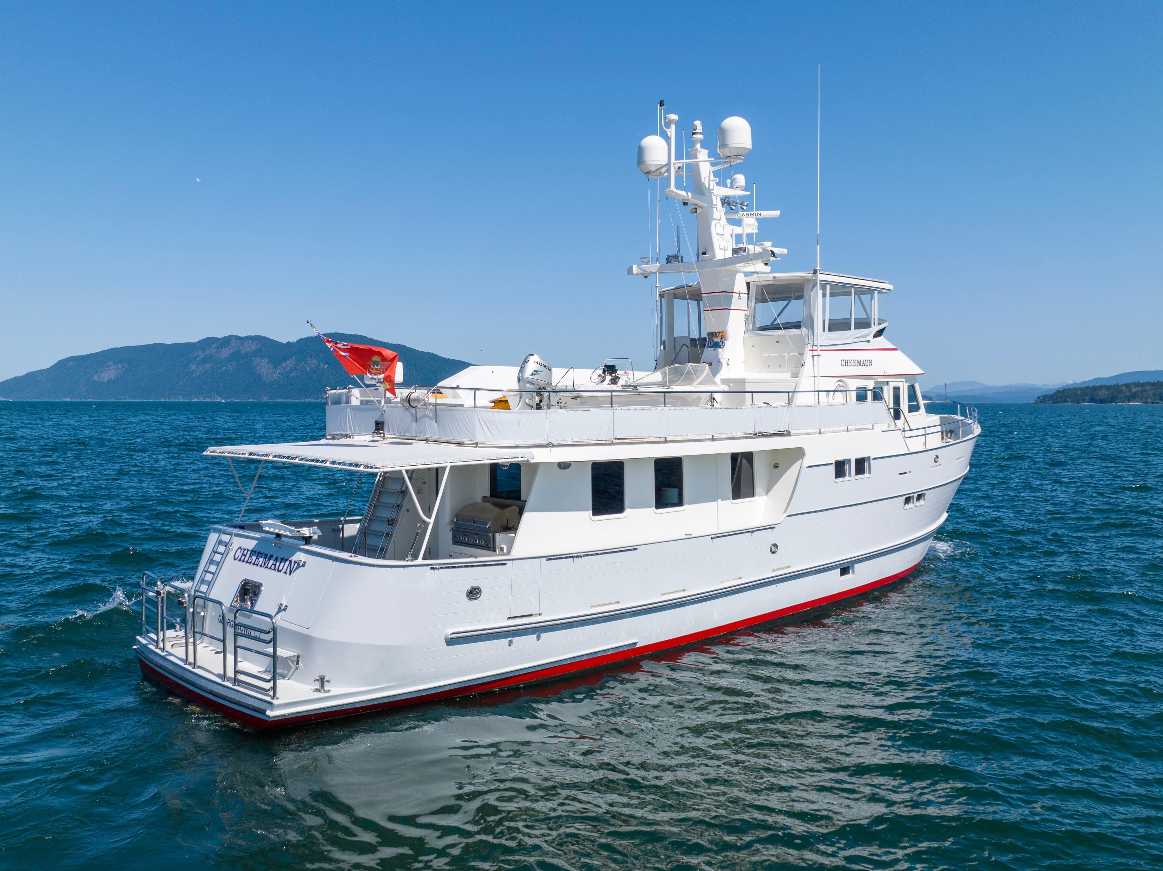 1998 Northern Marine 75 yacht cruising on open water with mountainous background.