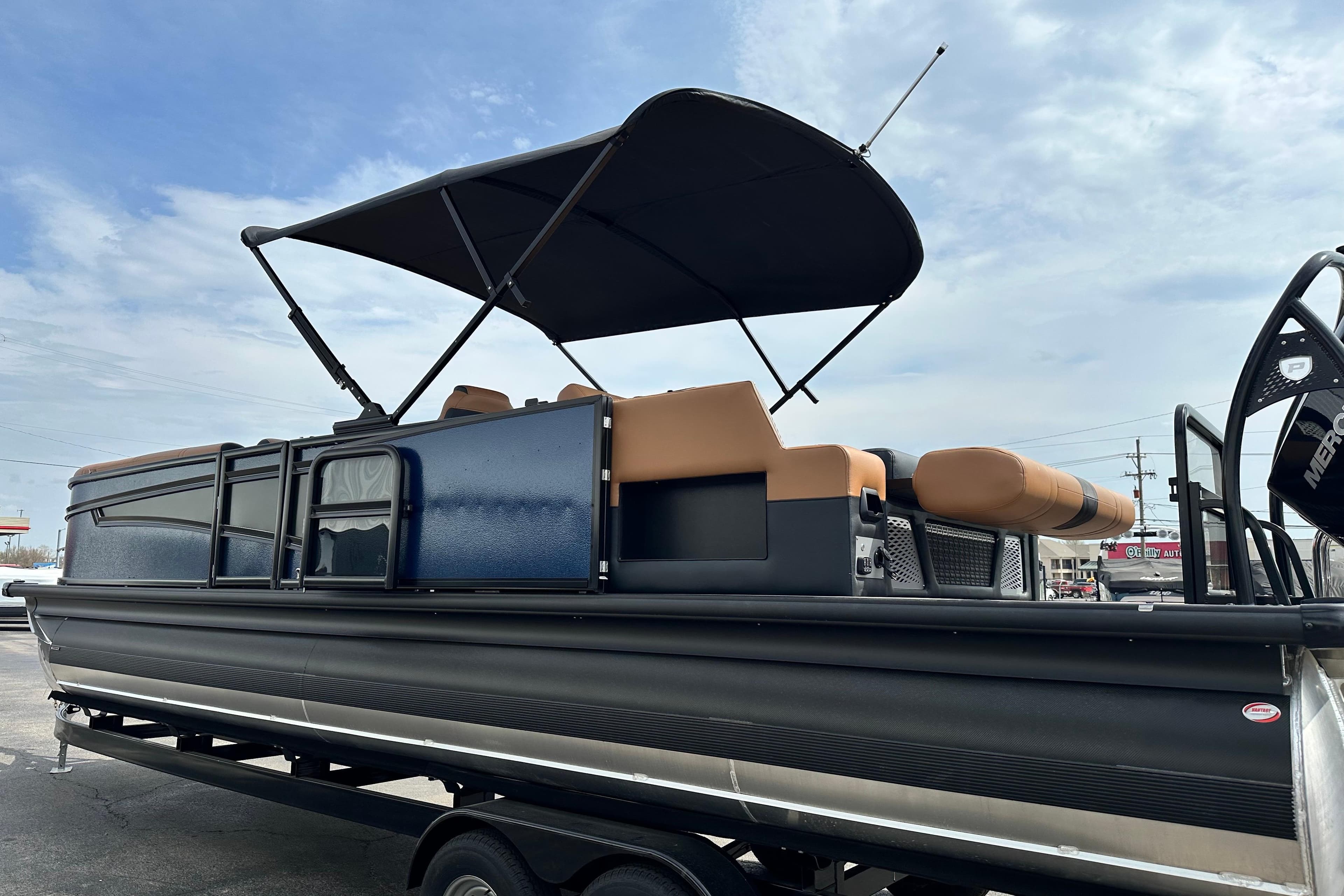2026 Premier 250 Intrigue RLO pontoon boat with canopy, parked on trailer.