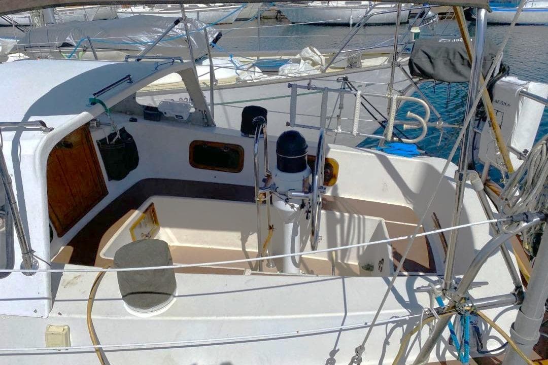 1983 Fraser 41 sailboat cockpit with steering wheel, docked at marina.
