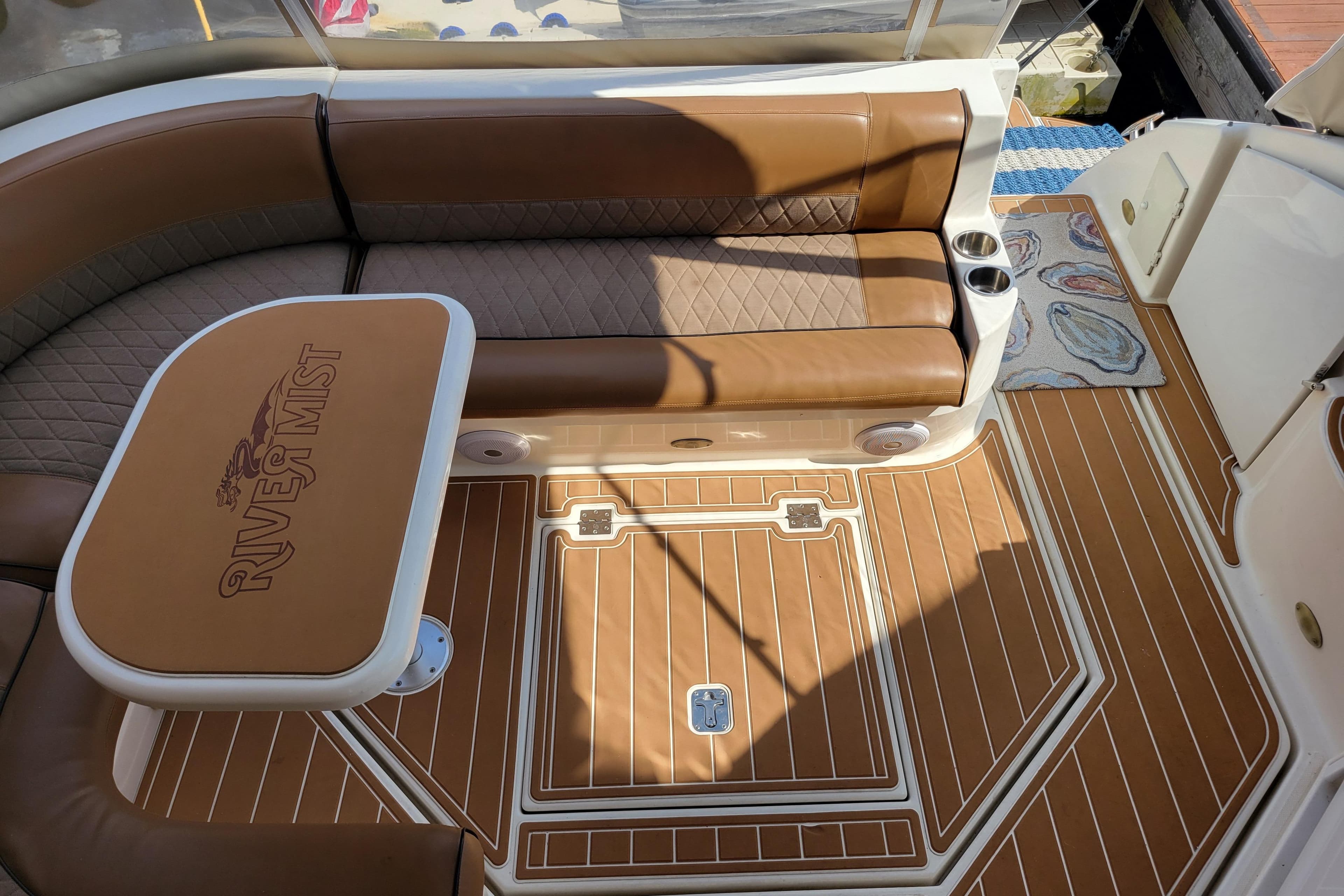 Luxurious 2004 Cruisers Yachts 400 Express interior with brown seating and custom table.