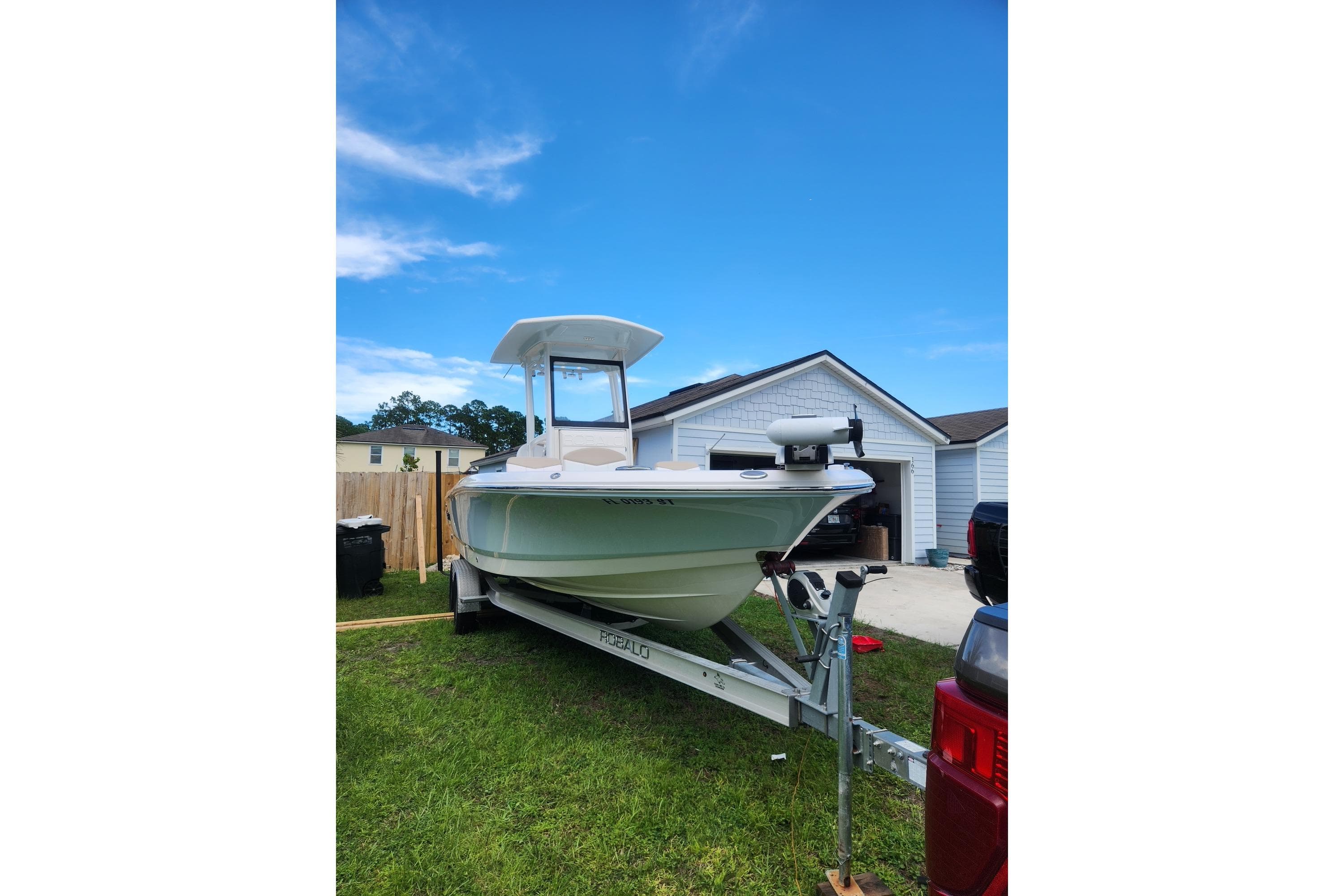 2020 Robalo 246 Cayman boat on trailer in residential driveway.