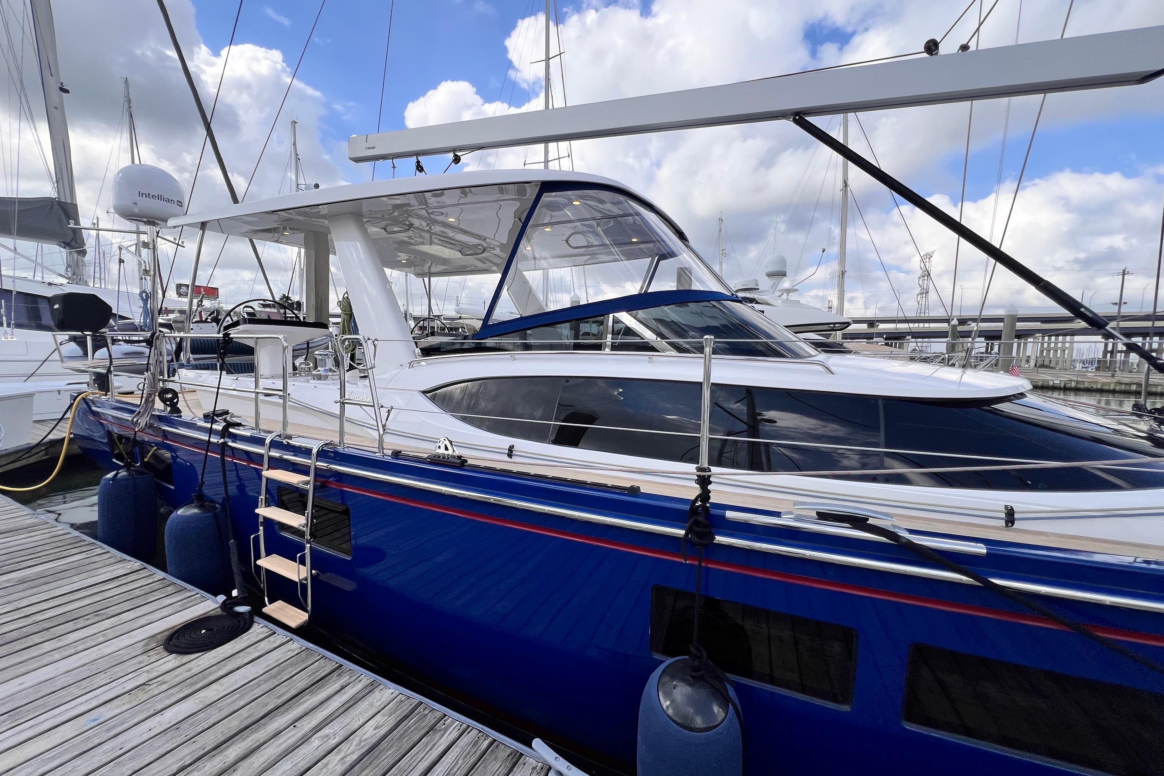 2024 Hylas H57 yacht docked at marina under cloudy sky.
