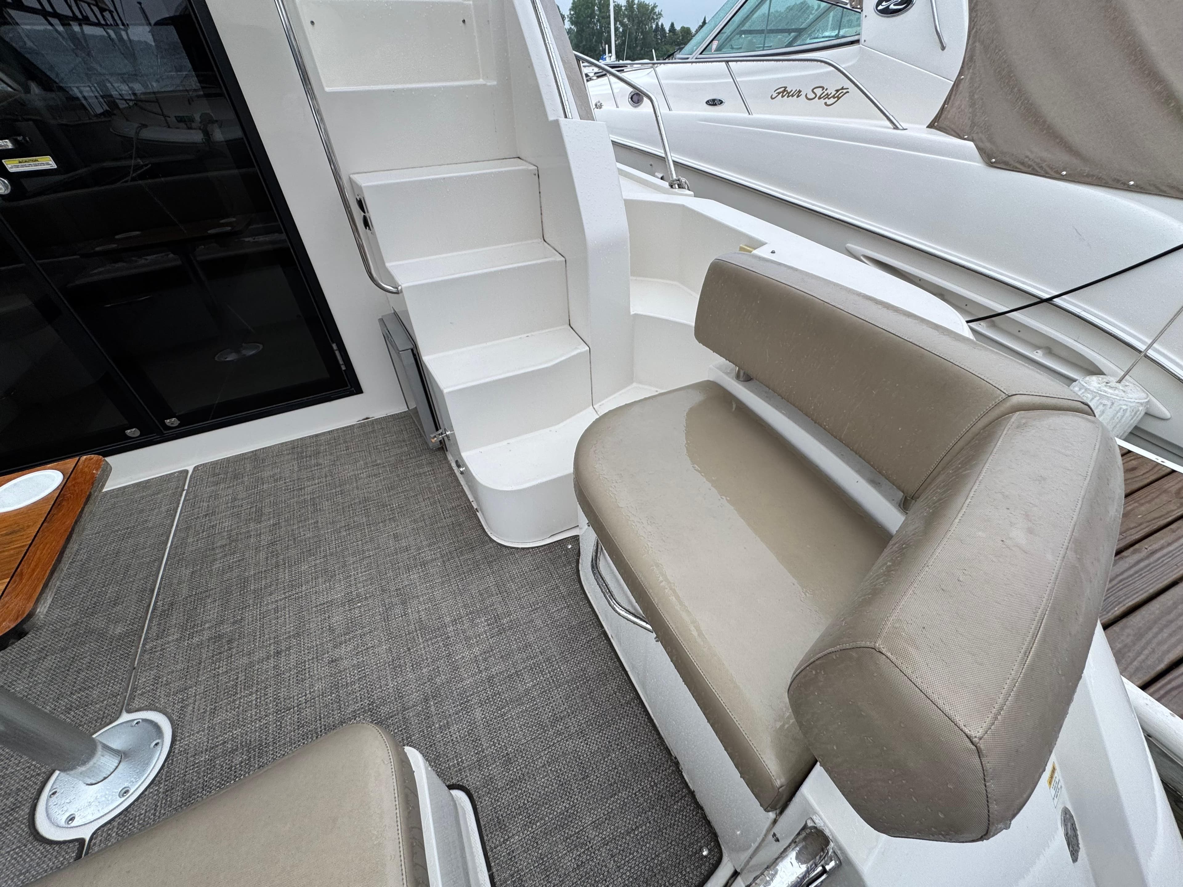2014 Carver C40 Command Bridge interior with seating and stairs, featuring beige upholstery.
