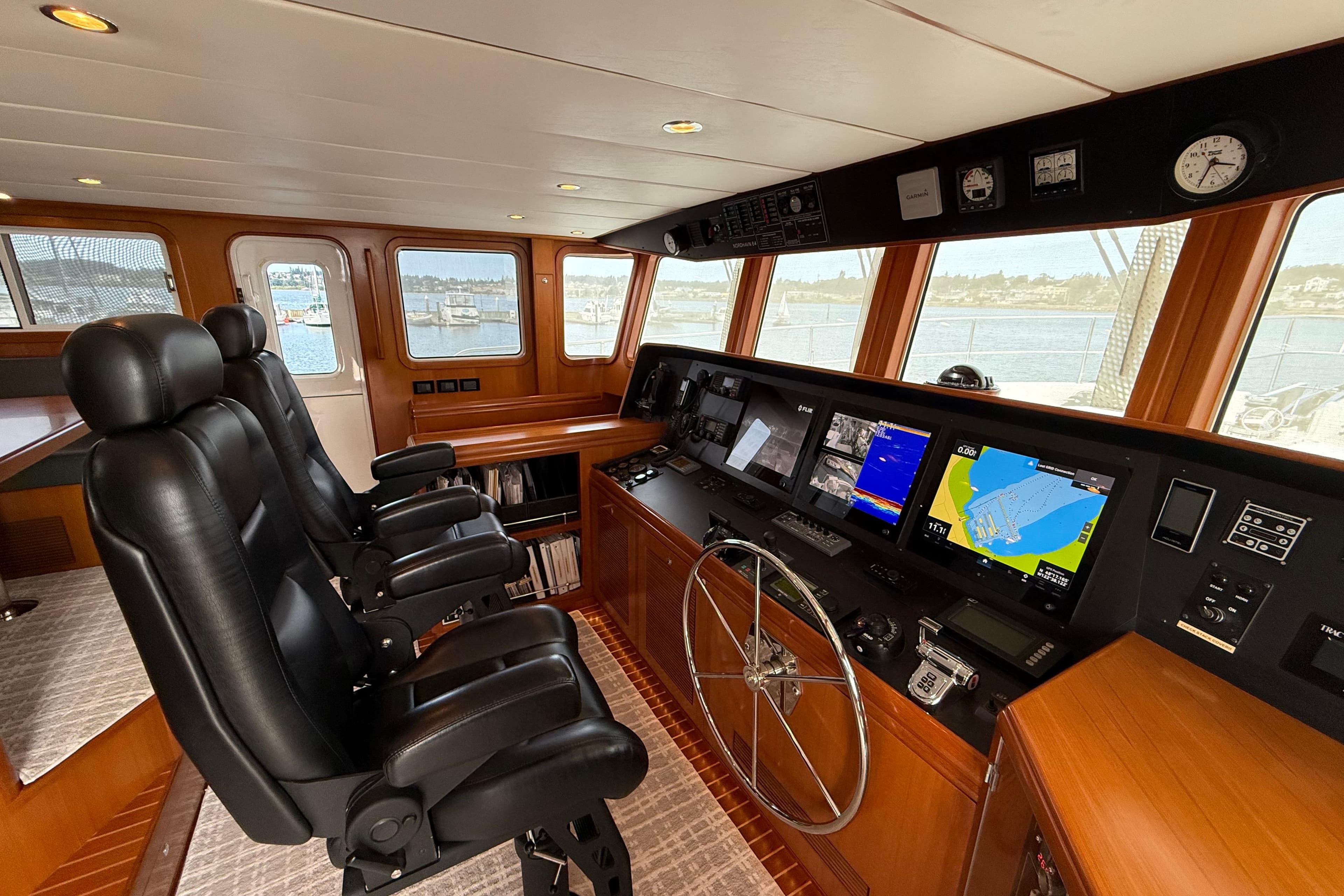 Luxurious 2009 Nordhavn N64 yacht helm with advanced navigation systems and leather seating.