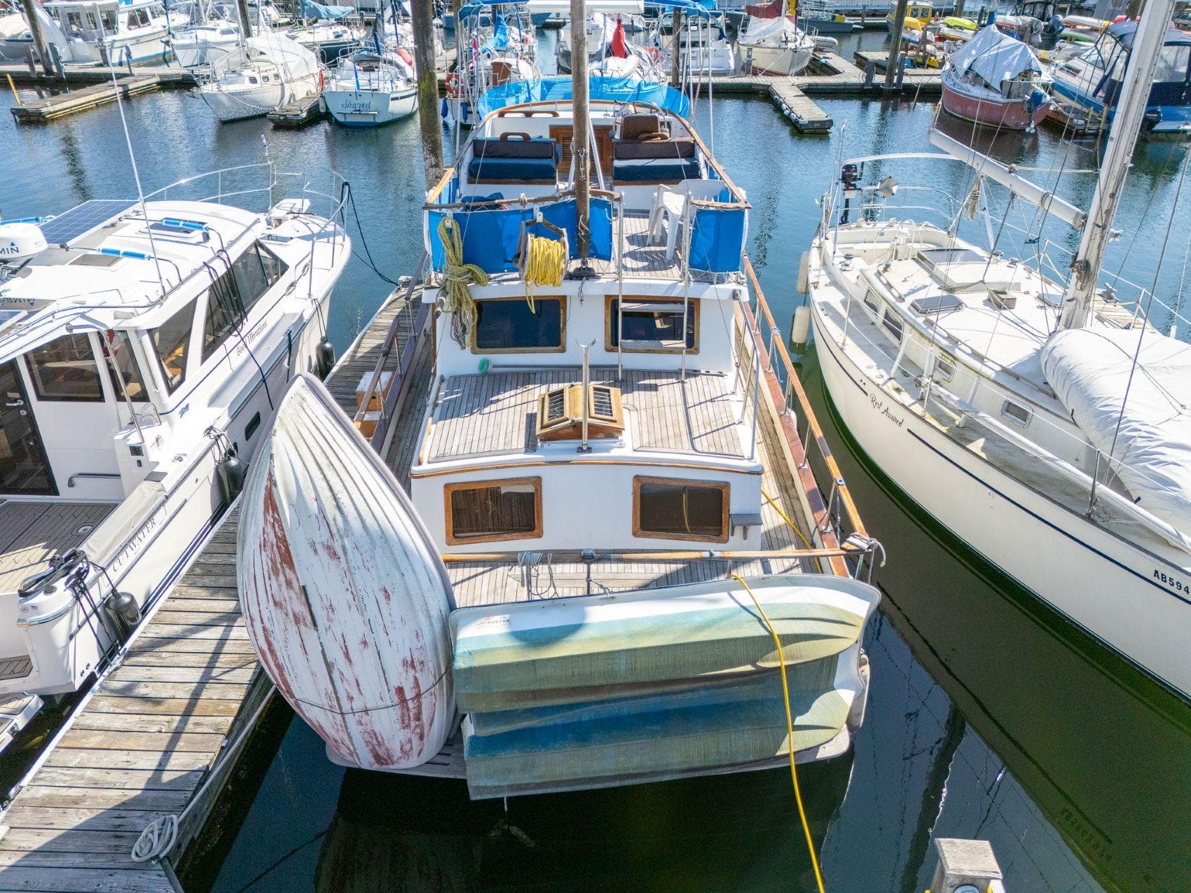 1980 Grand Mariner 36 Tri-Cabin Trawler docked at marina, surrounded by other boats.
