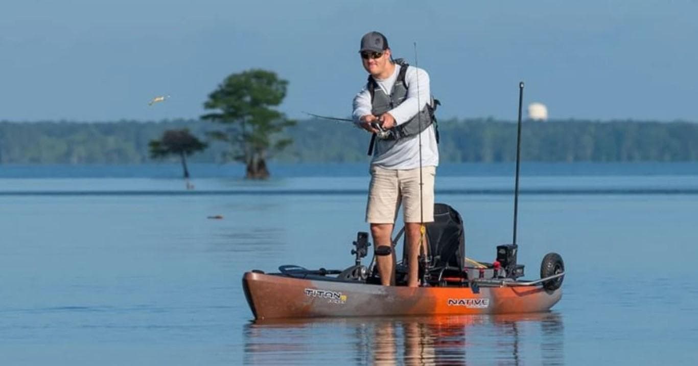 Man fishing on a 2023 Native Watercraft Titan Propel 12 kayak in a calm lake.