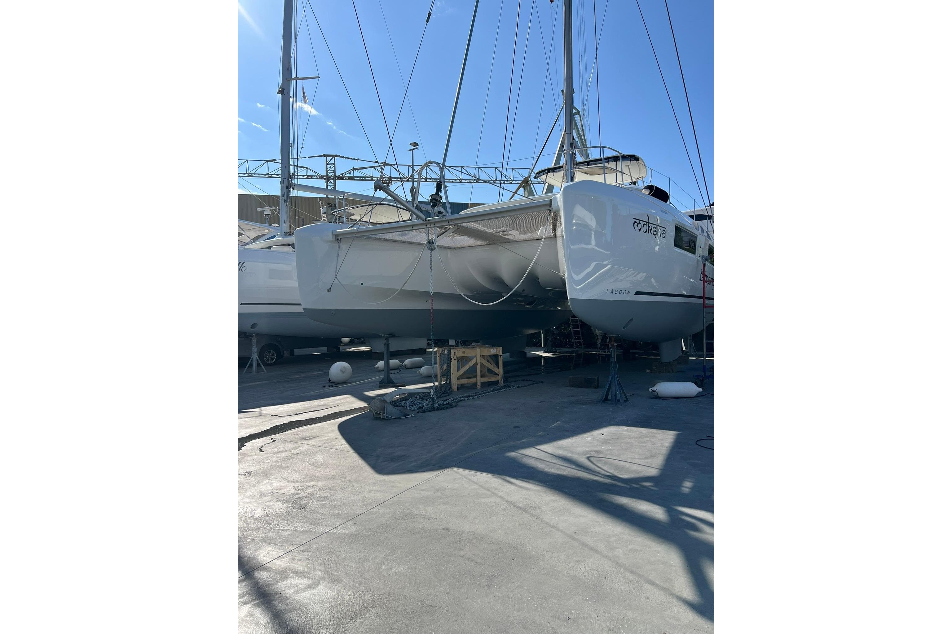 2020 Lagoon 50 catamaran in dry dock, side view under bright sunlight.