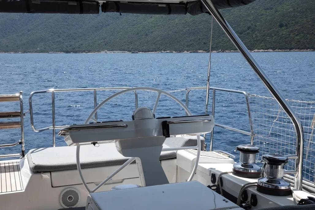Cockpit view of 2020 Jeanneau 64 yacht on calm blue waters.