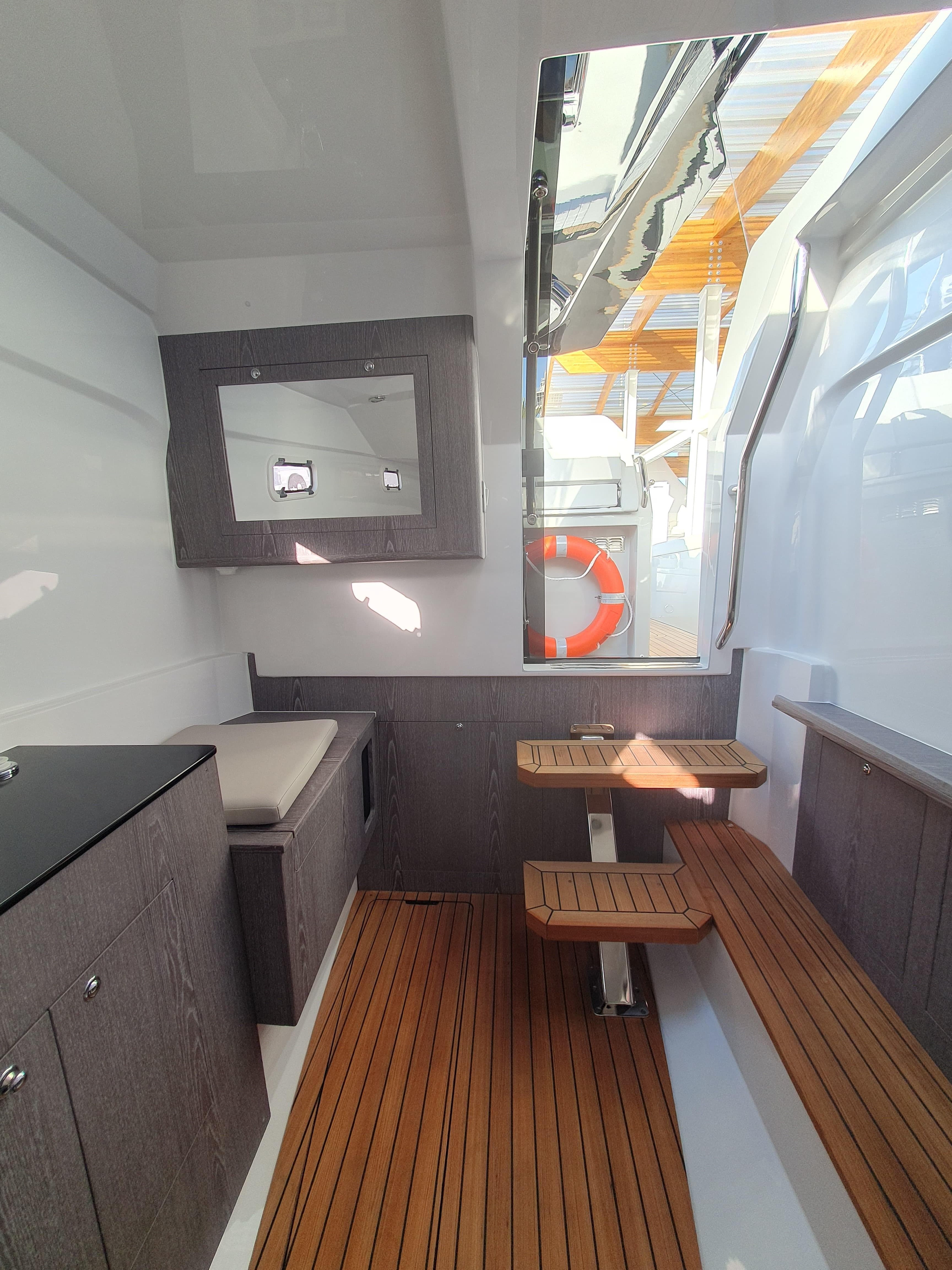 Interior of 2025 Pirelli PIRELLI 35 boat with wooden flooring and seating.