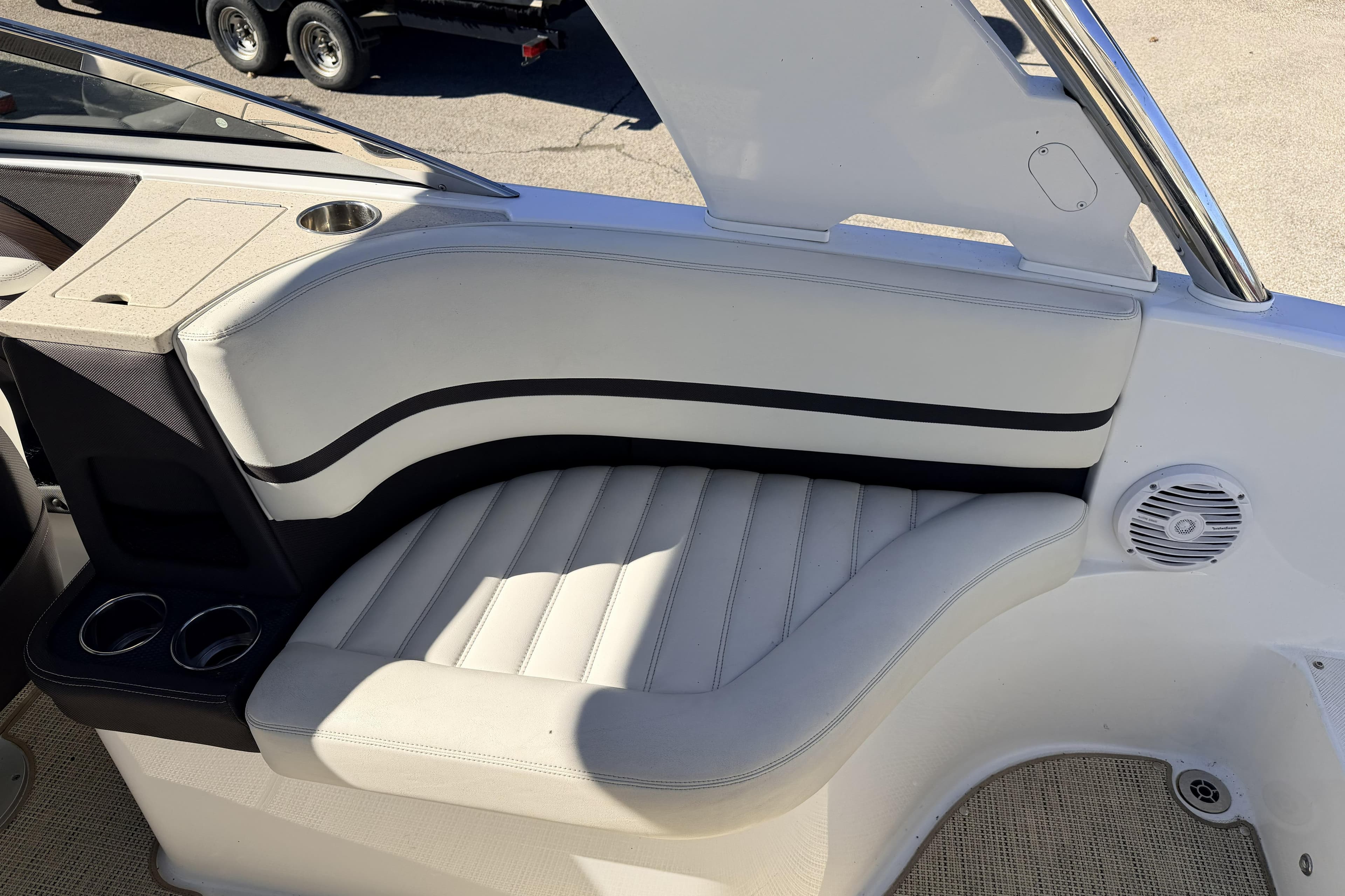 Luxurious seating area in a 2016 Cobalt R7 boat with cup holders and speaker.