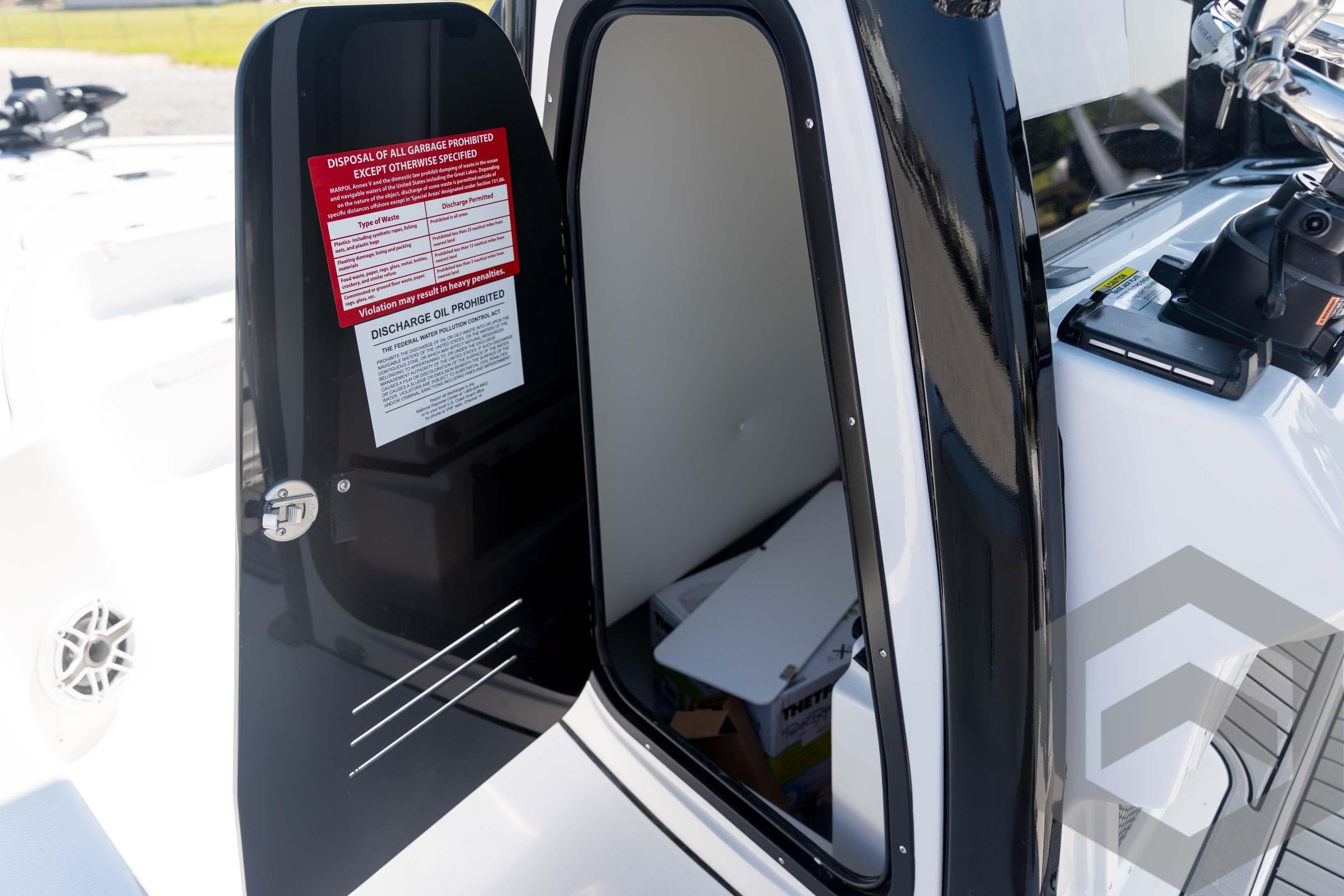 2026 Tidewater 2410 Bay Max boat interior with open storage compartment door.