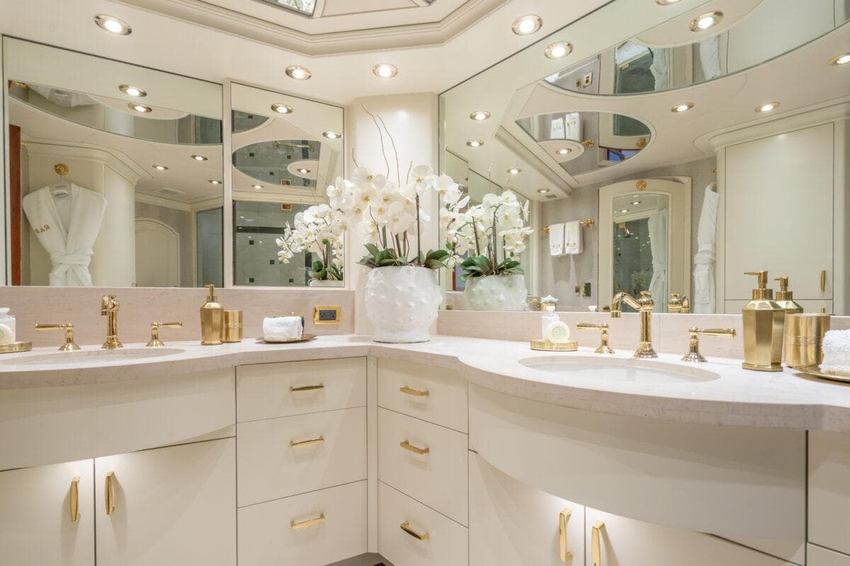 Luxurious bathroom with gold fixtures, mirrors, and elegant decor on a 2004 Crescent Raised Pilothouse yacht.