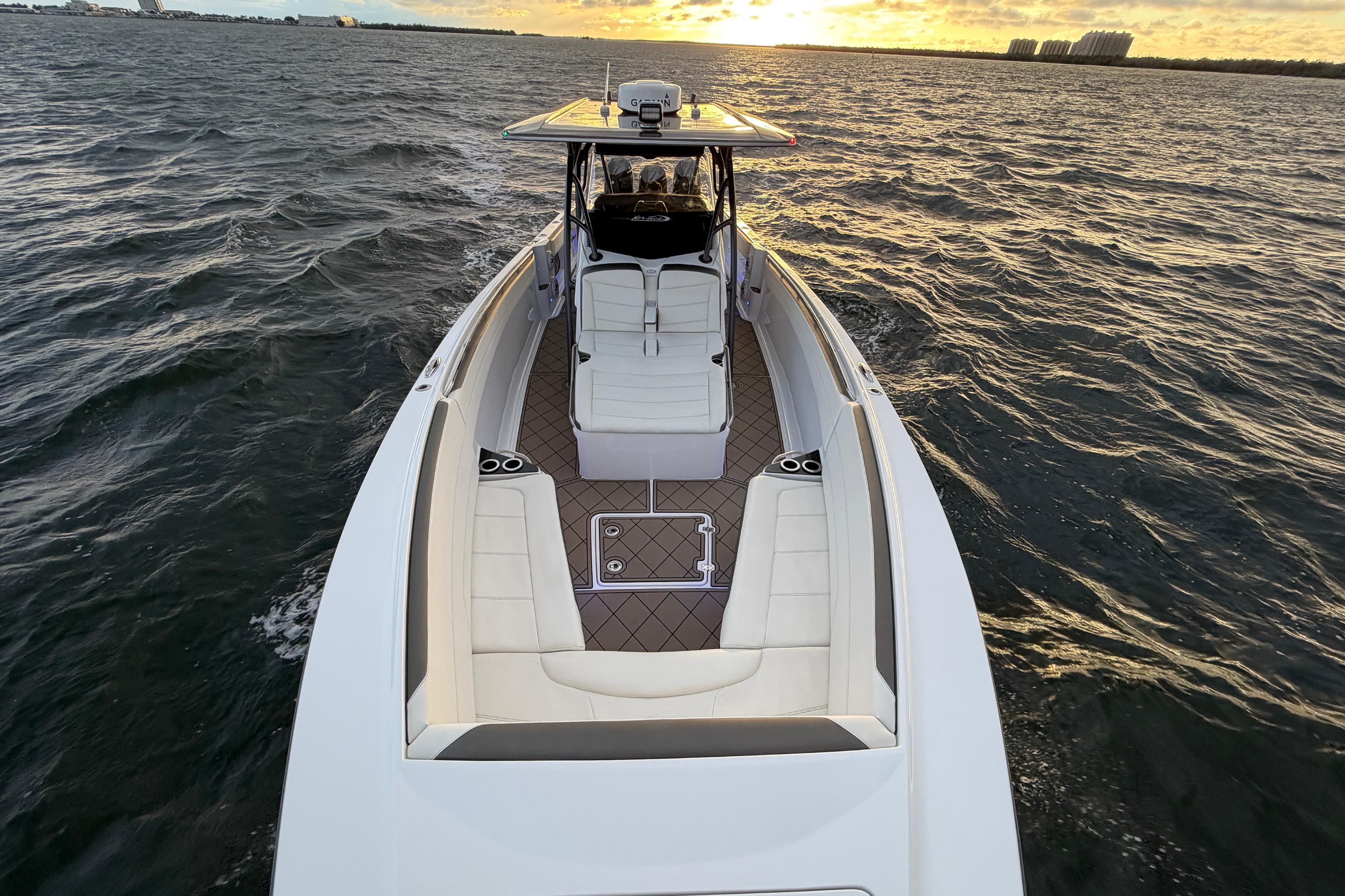 2021 Nor-Tech 390 Sport Center Console boat cruising at sunset on open water.