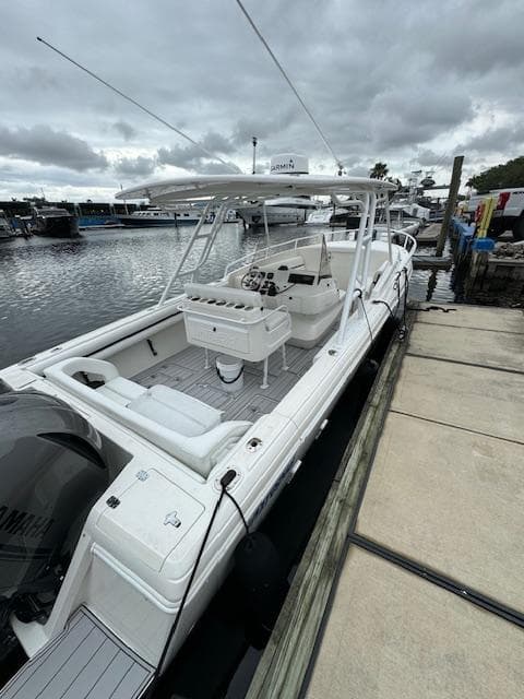2008 Intrepid 327 Cuddy boat docked at marina under cloudy skies.