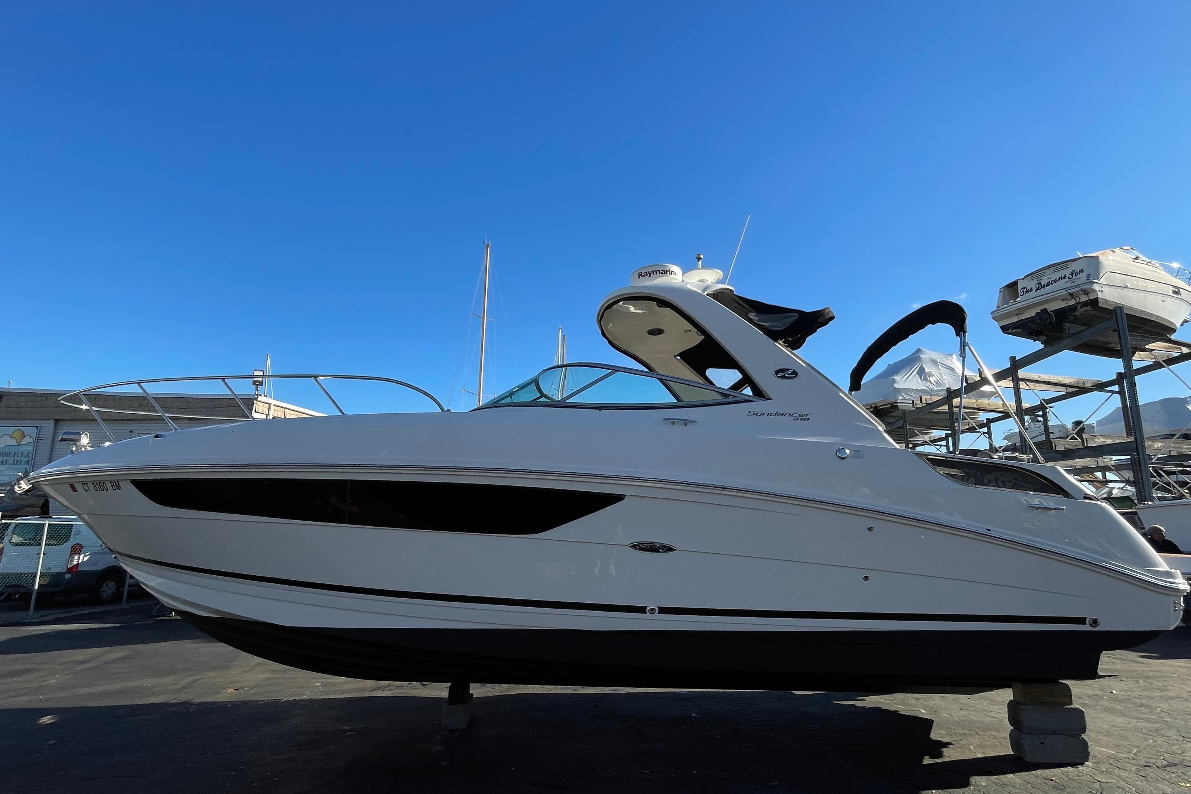 2016 Sea Ray 310 Sundancer boat on display under clear blue sky.