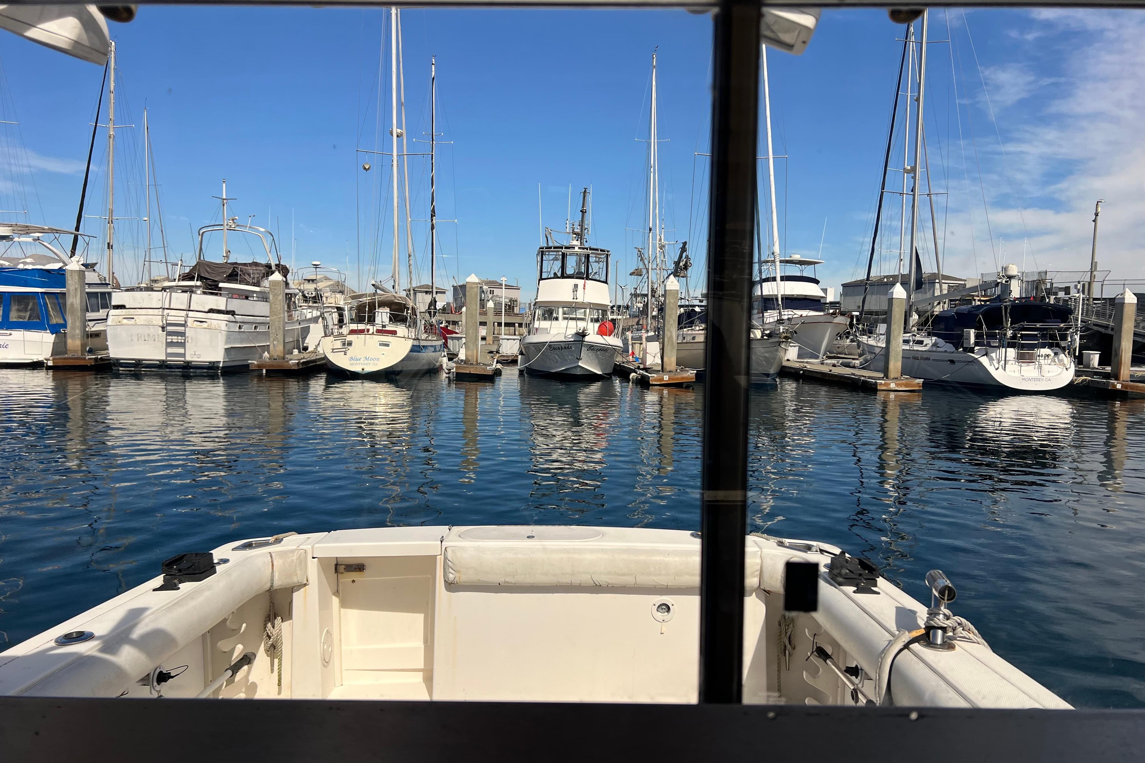 View from a 2005 Shamrock 270 Mackinaw boat in a marina with docked vessels.